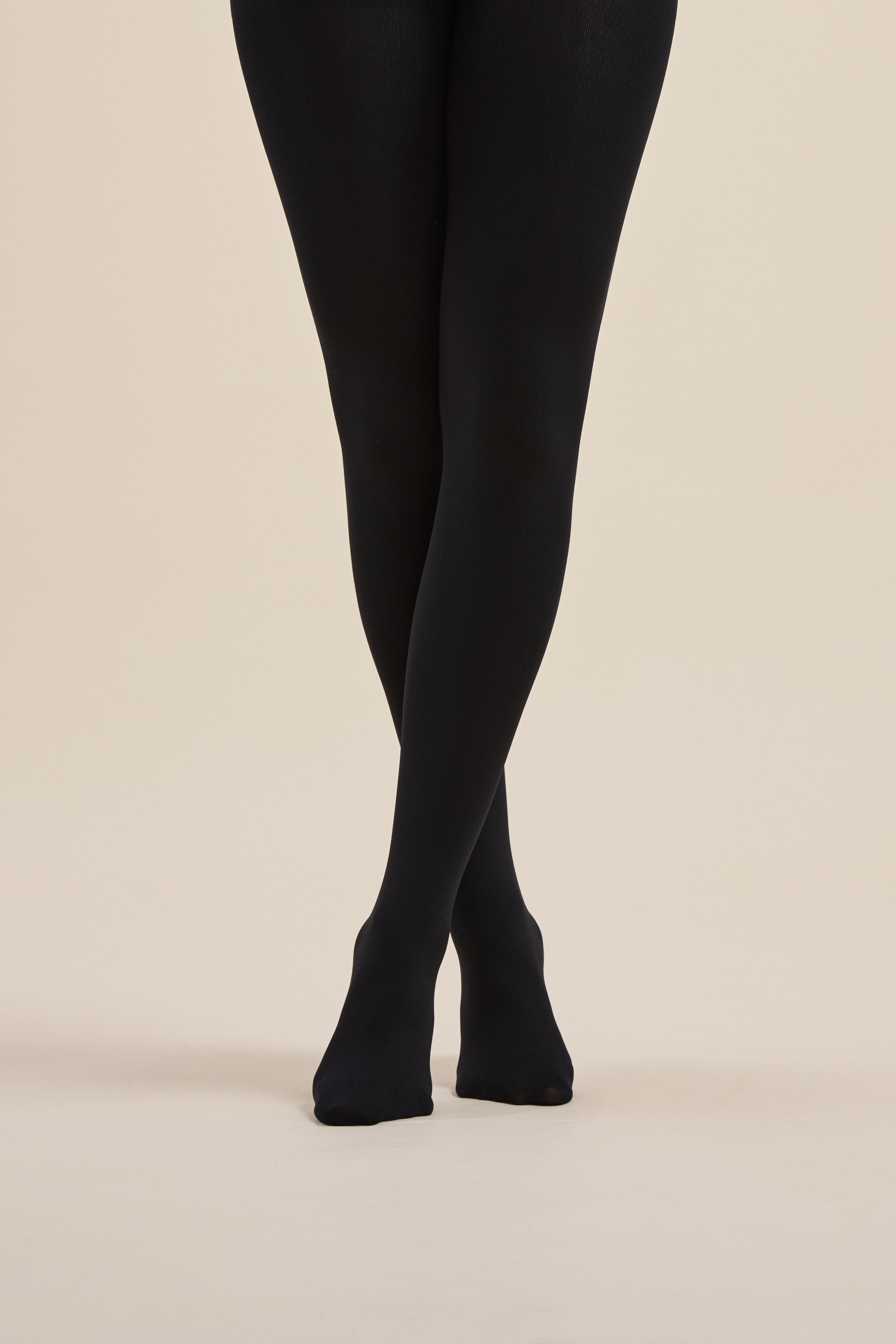 Model wears Max Recycled Fleecy Tights, legs crossed, against a neutral background.