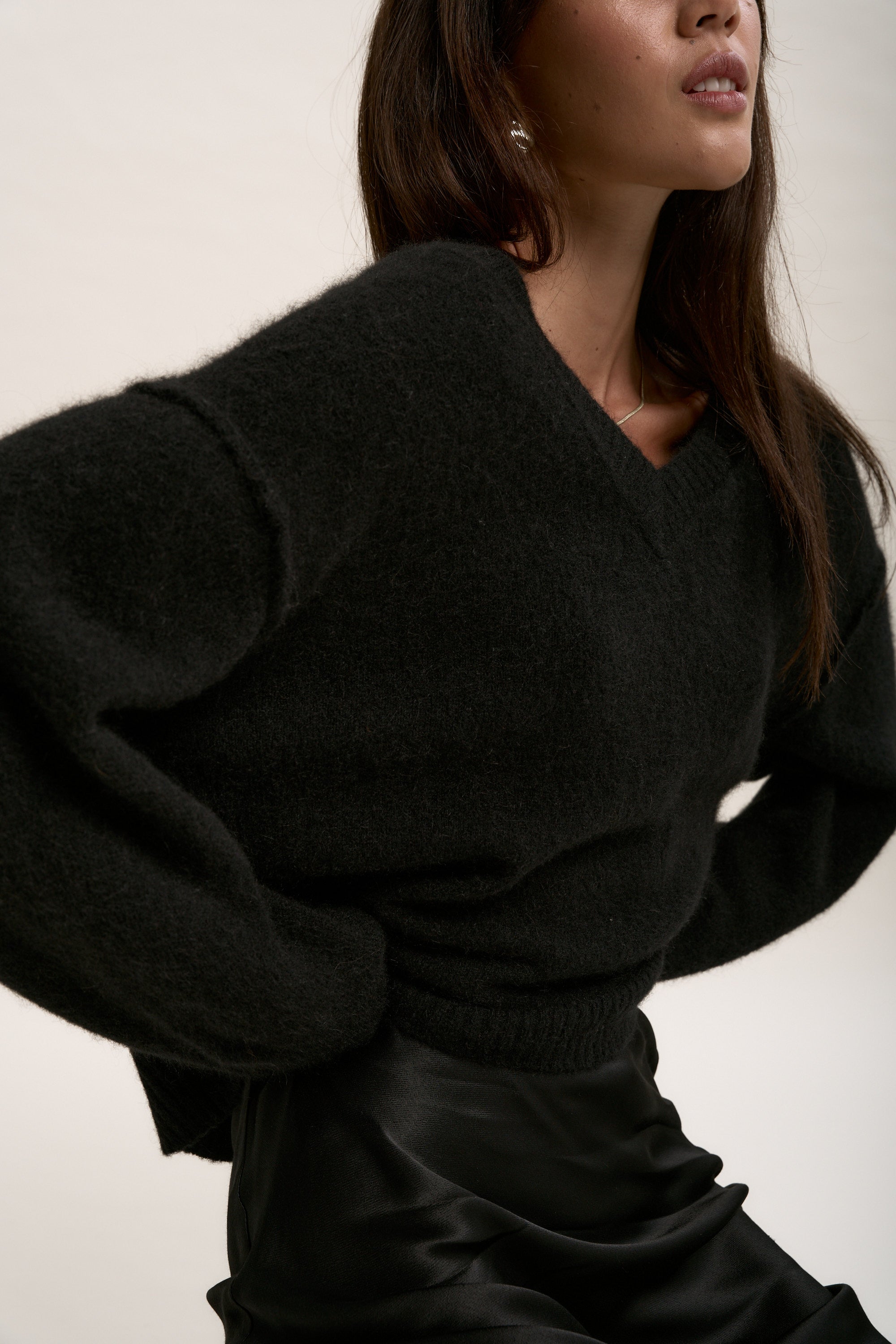 Model wears Max’s The Luxe Whisper V Neck Sweater, posing with hands on hips against a neutral backdrop.