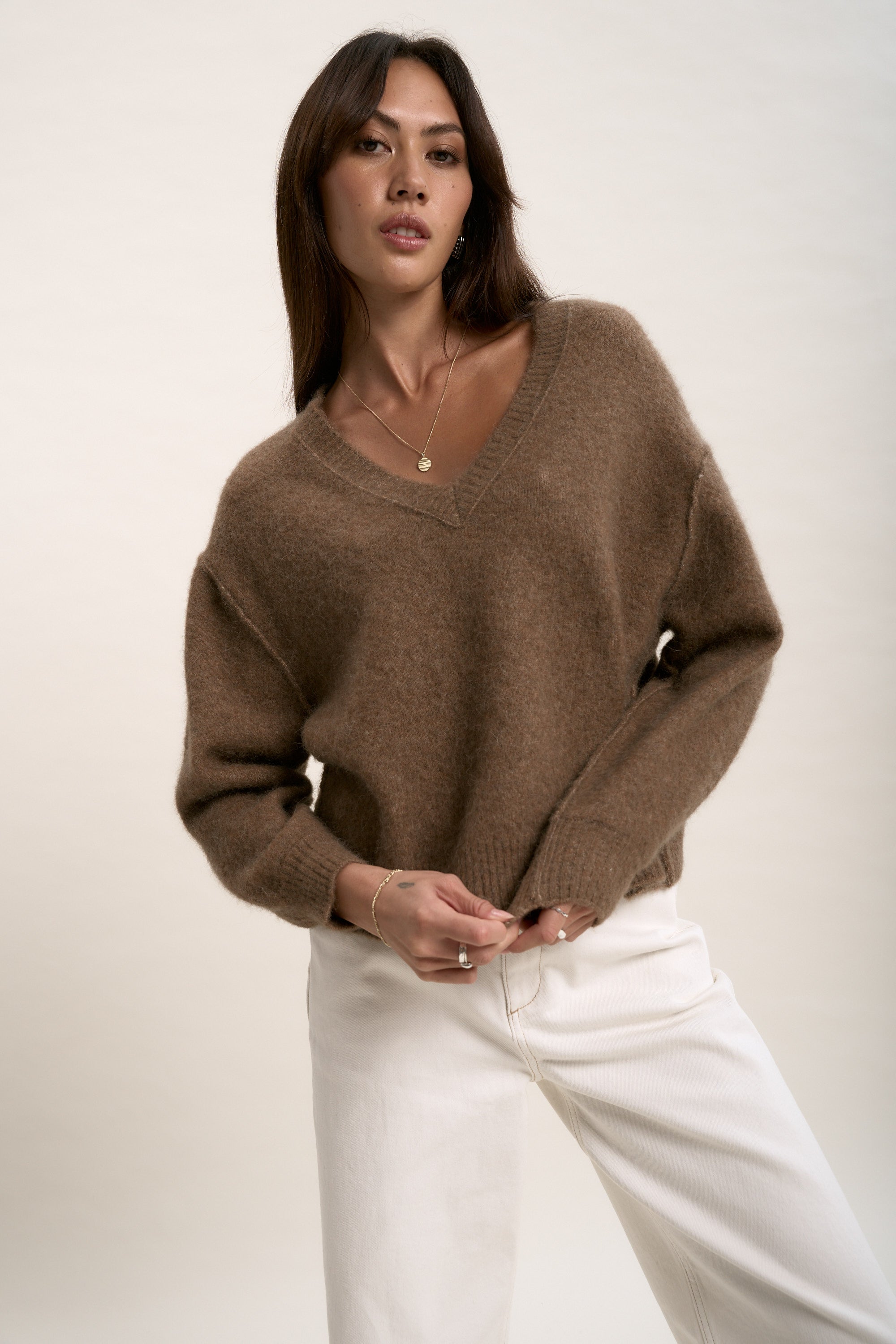 Woman in The Luxe Whisper V Neck Sweater by Max and white pants against a light background.