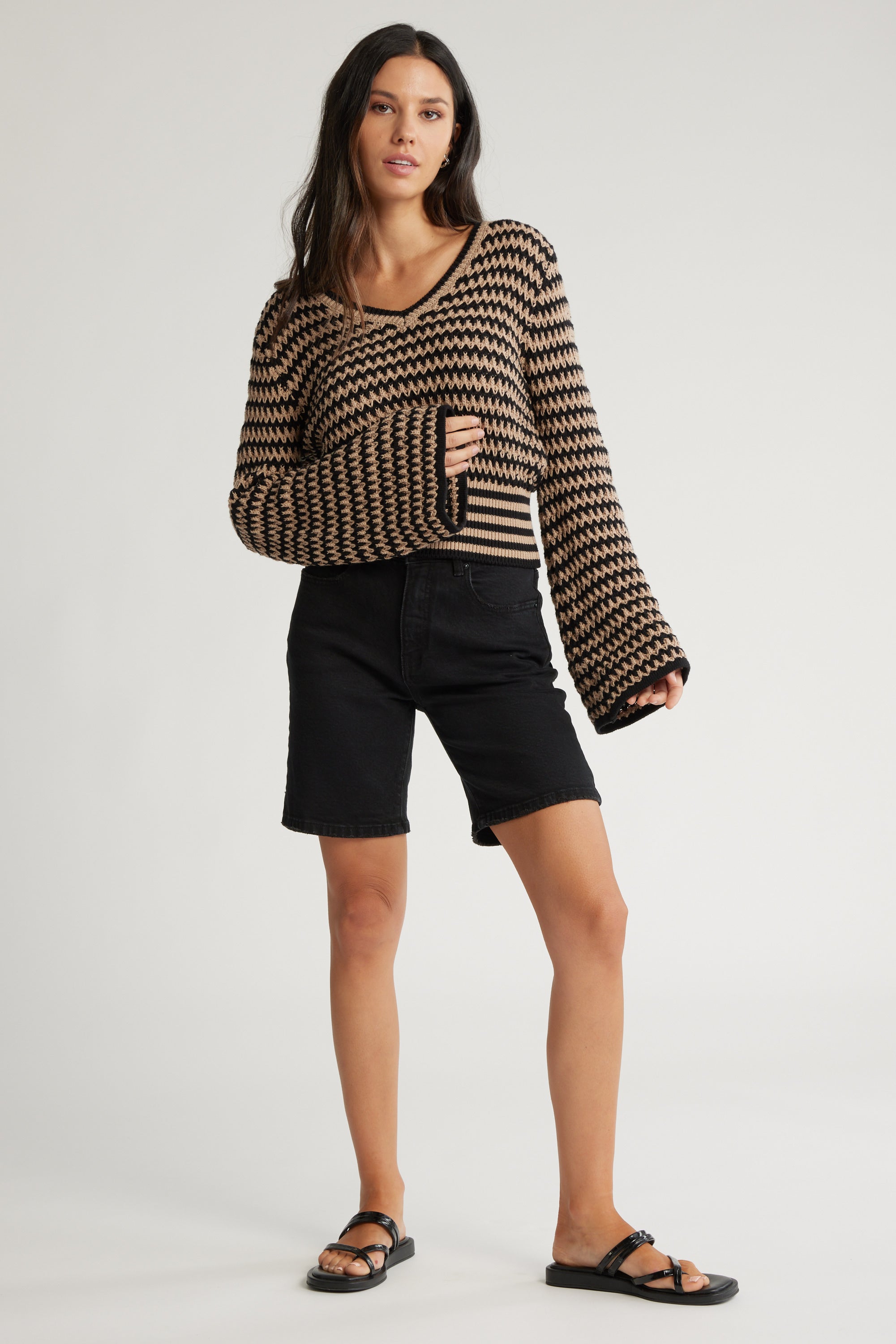 Woman wearing The Relaxed Straight Denim Short by Max, zigzag sweater, and sandals.