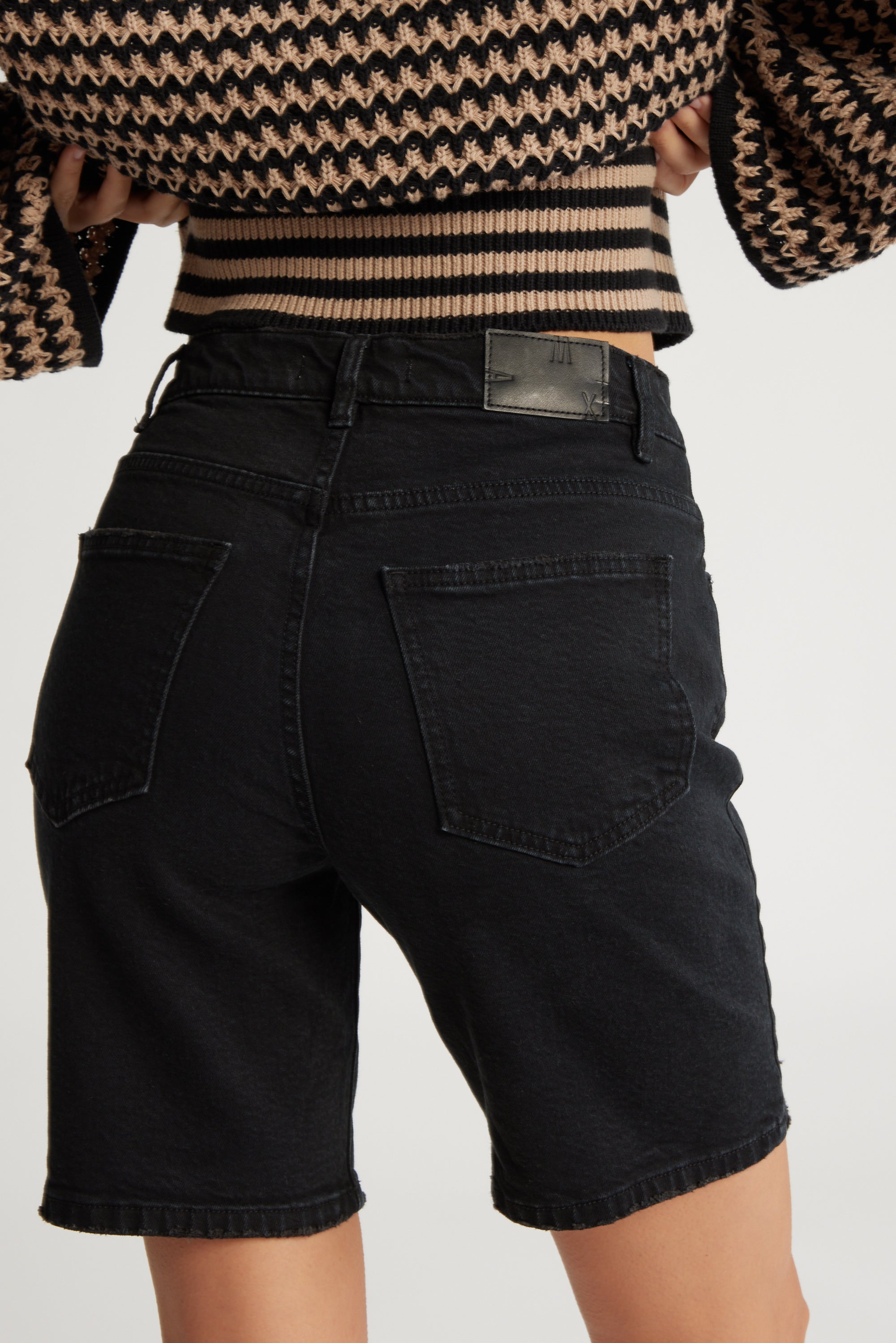 Model in Max’s The Relaxed Straight Denim Short and a striped, cropped sweater, back view.