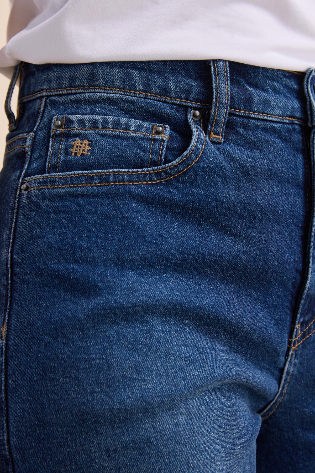 Close-up of Max Nevada Wide sustainable denim jeans with white shirt, pocket, and belt loop.