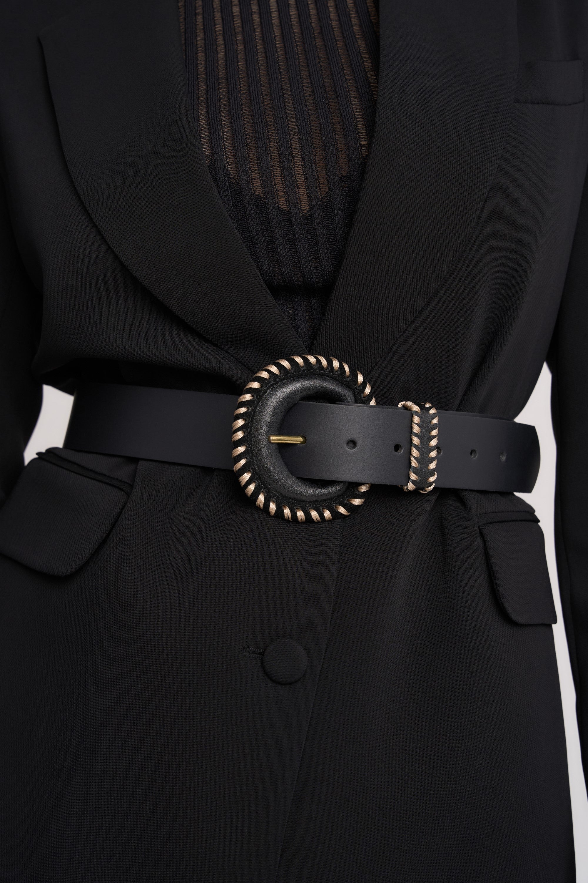 Person in black blazer with Max's The Contrast Stitch Belt, made in NZ, gold-trimmed buckle.