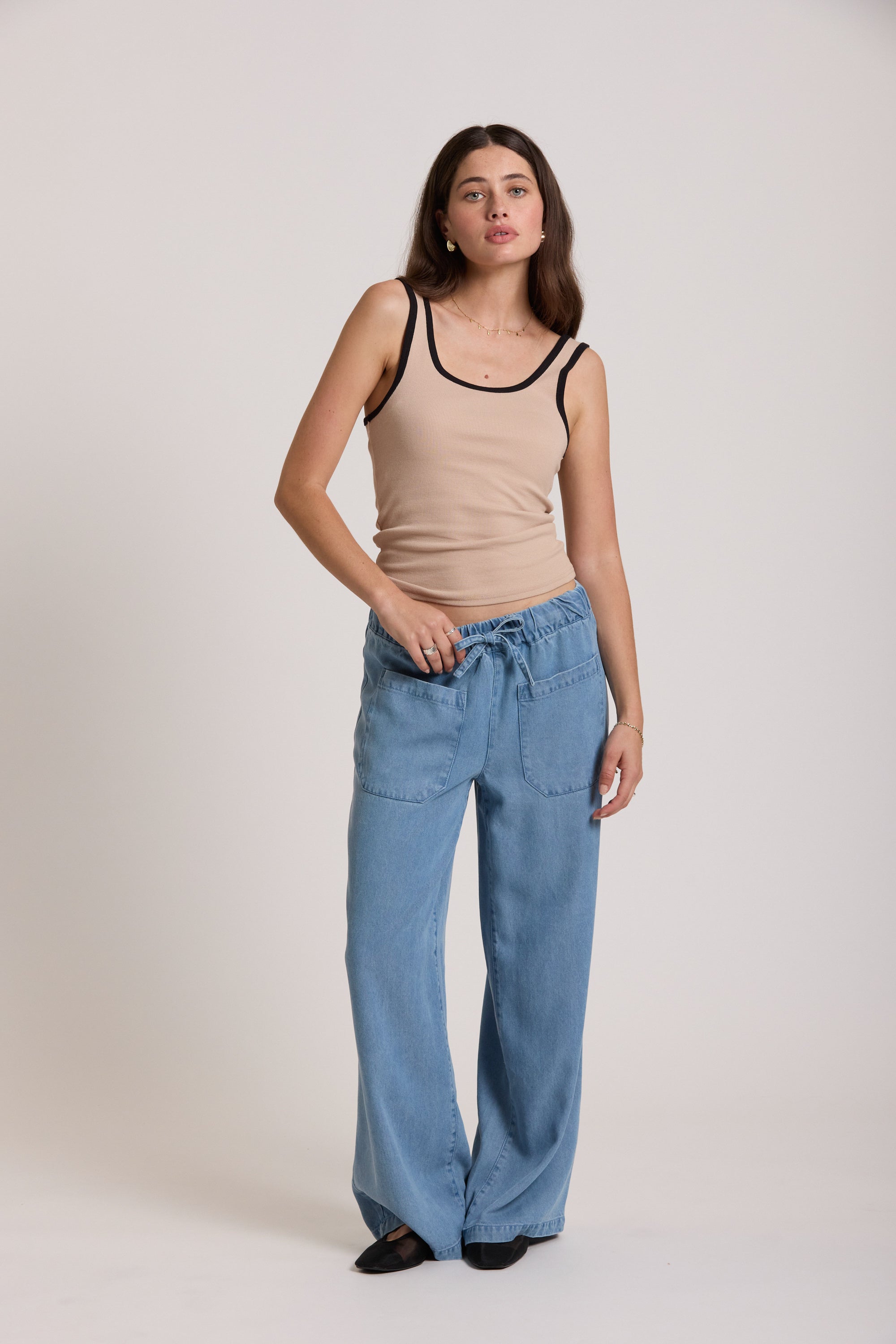Woman in Max's The Contrast Trim Tank and loose blue jeans against a plain white background.