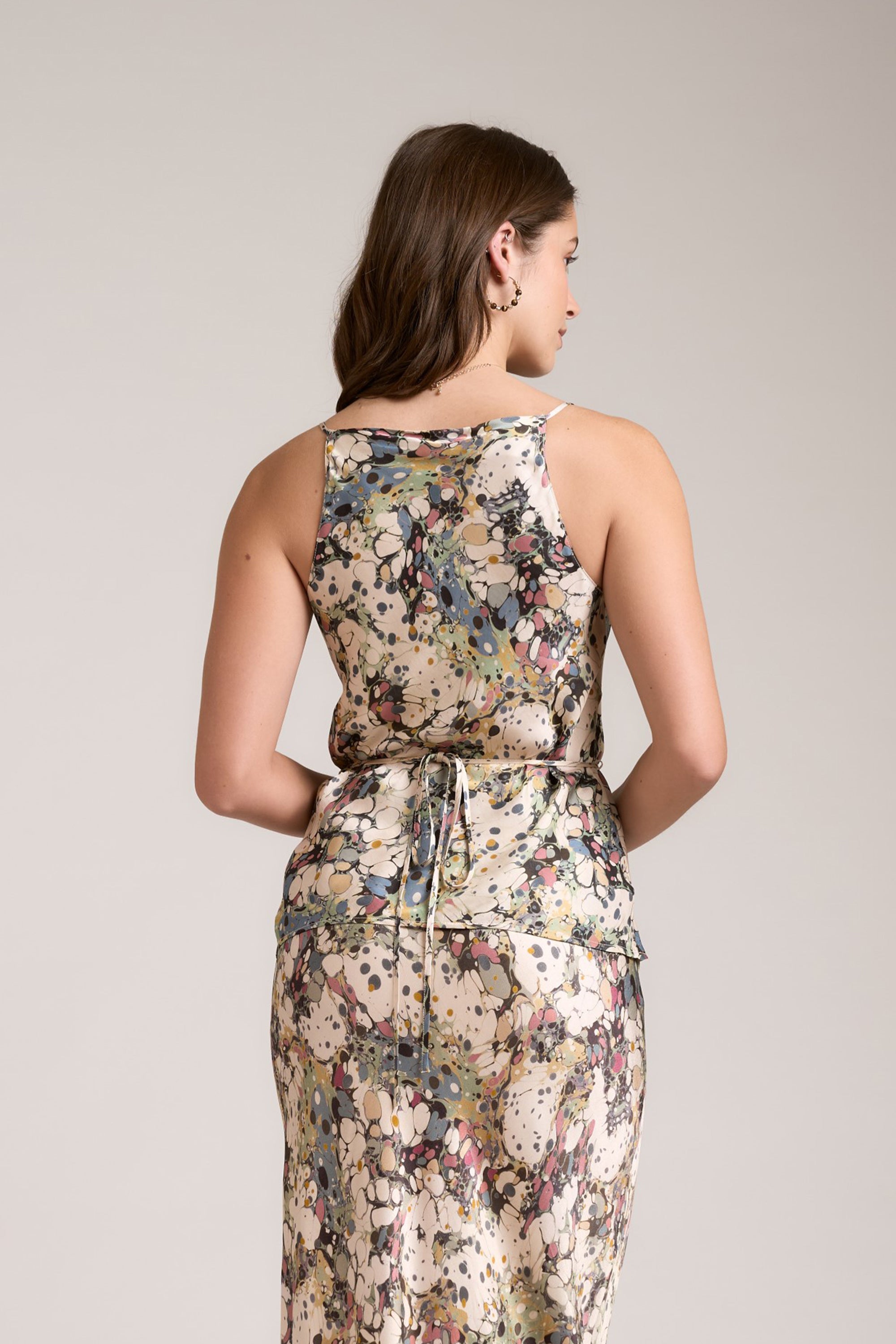 Woman in a sleeveless Max Lola Cowl Neck Top, marbled print, facing away.