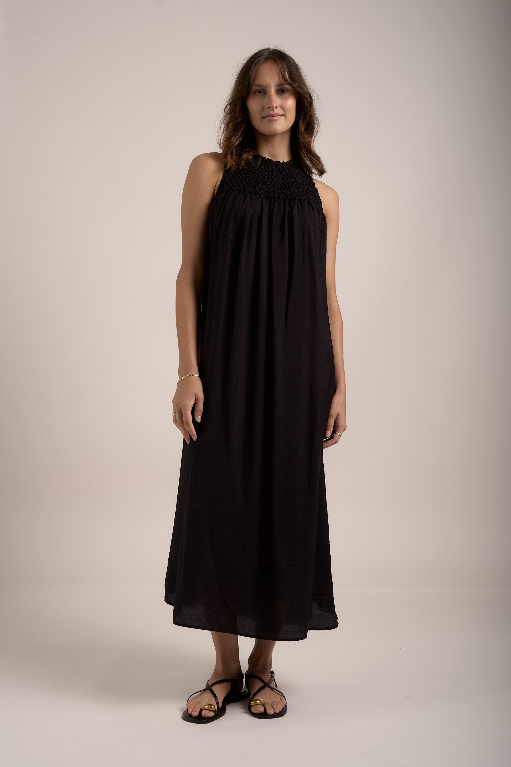 Woman in the Sherry Smock Detail Dress by Max stands against a plain background.