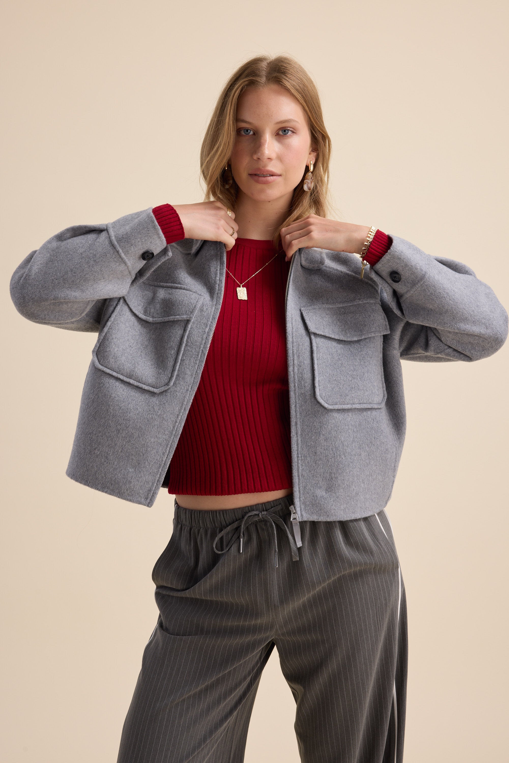 Woman in Max's Zip Front Wool Blend Cropped Coat poses stylishly in a bold, oversized look.