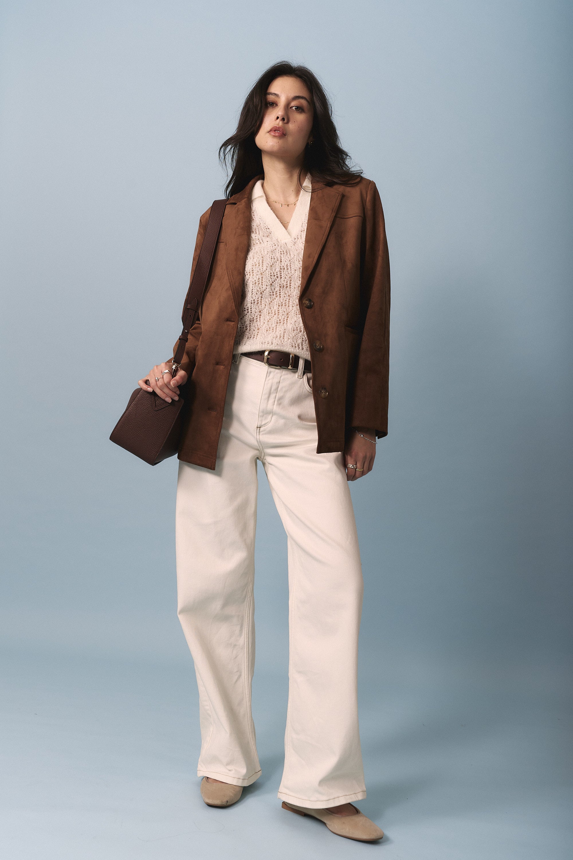 Woman in brown blazer, Max Taylor Short Sleeve Knit, cream pants, beige shoes, with a brown bag.