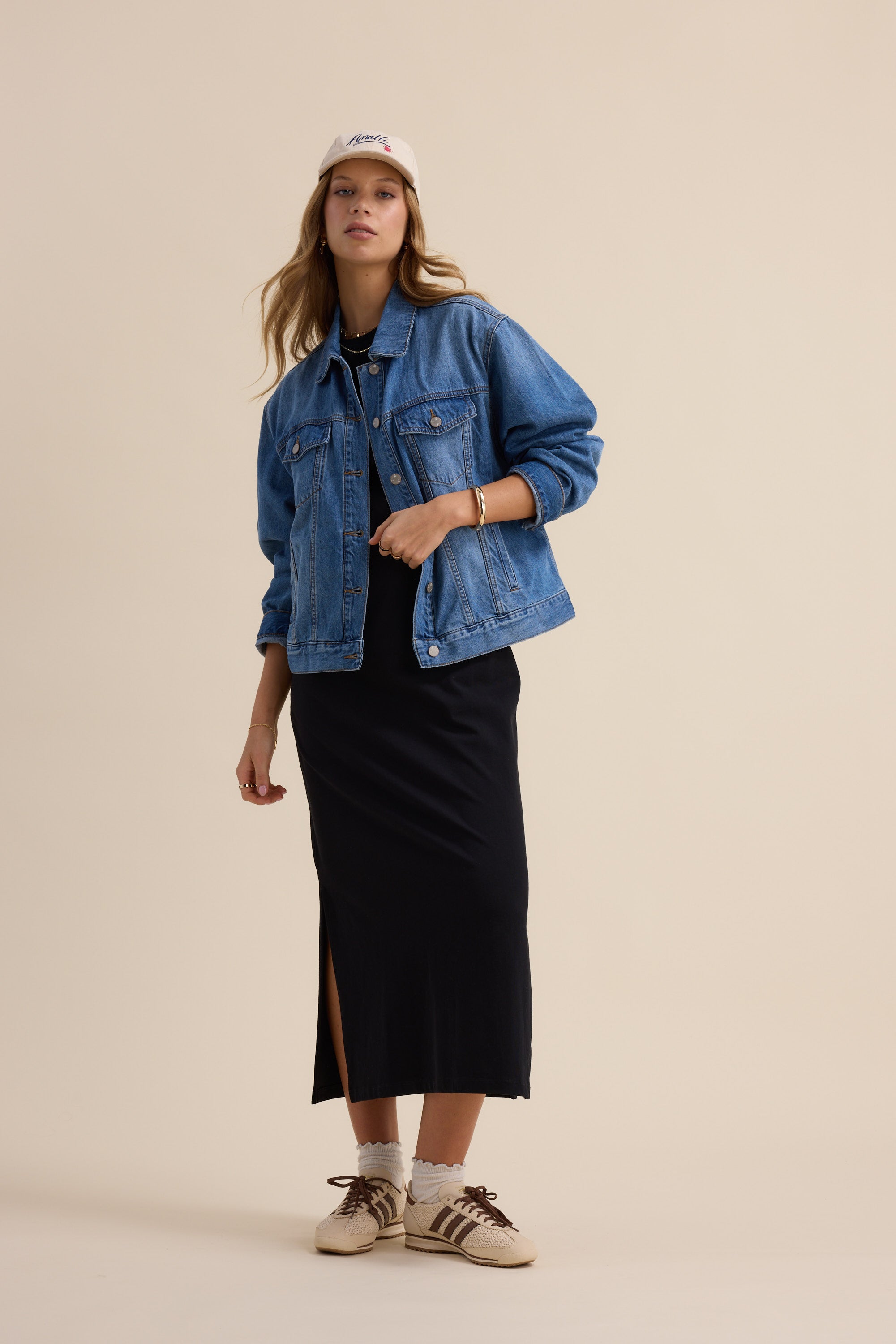 Woman in The Tee Shirt Dress by Max and denim jacket stands against a plain background.