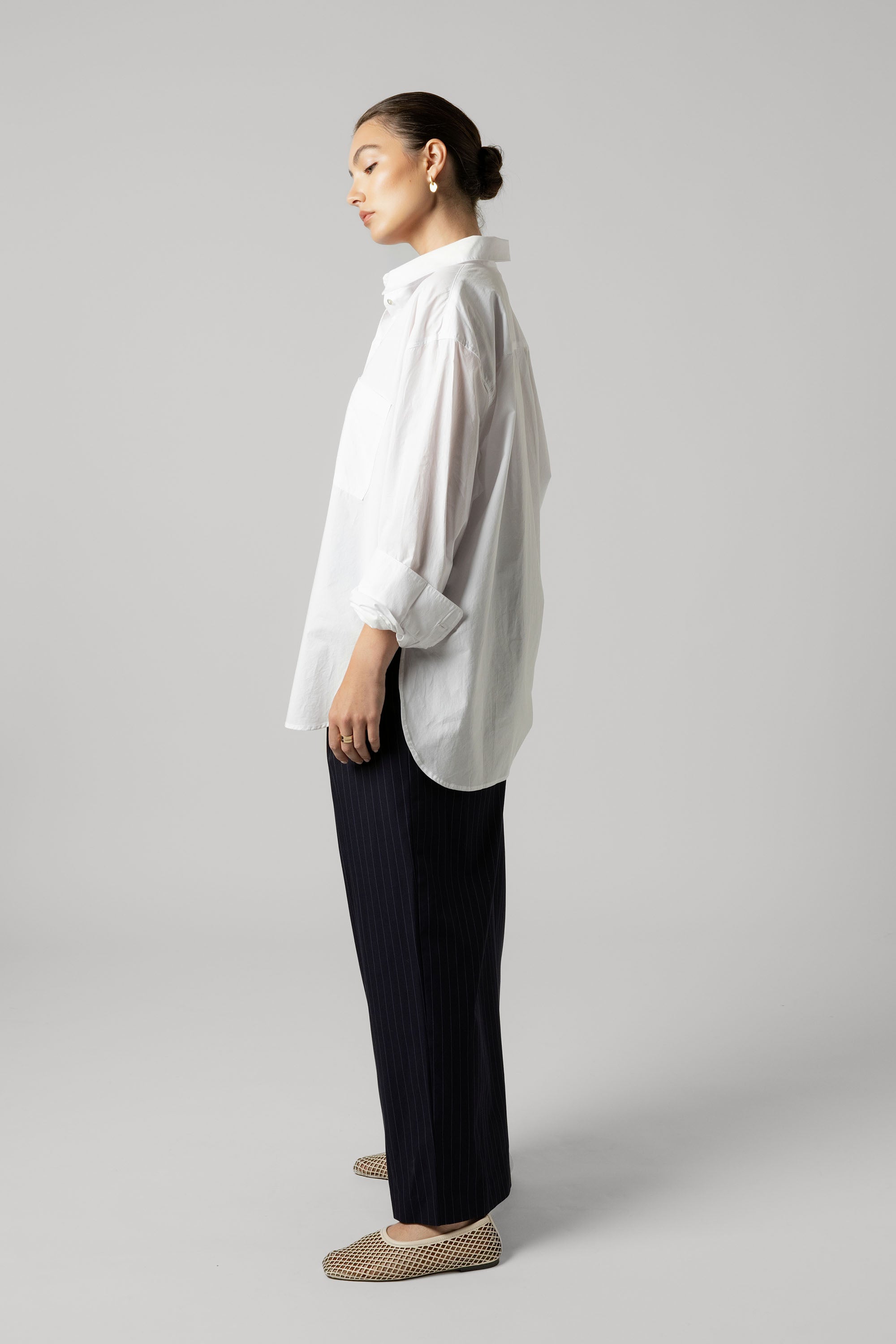 Woman in Max's Everyday Tailored Shirt—an organic cotton poplin essential—stands in profile.