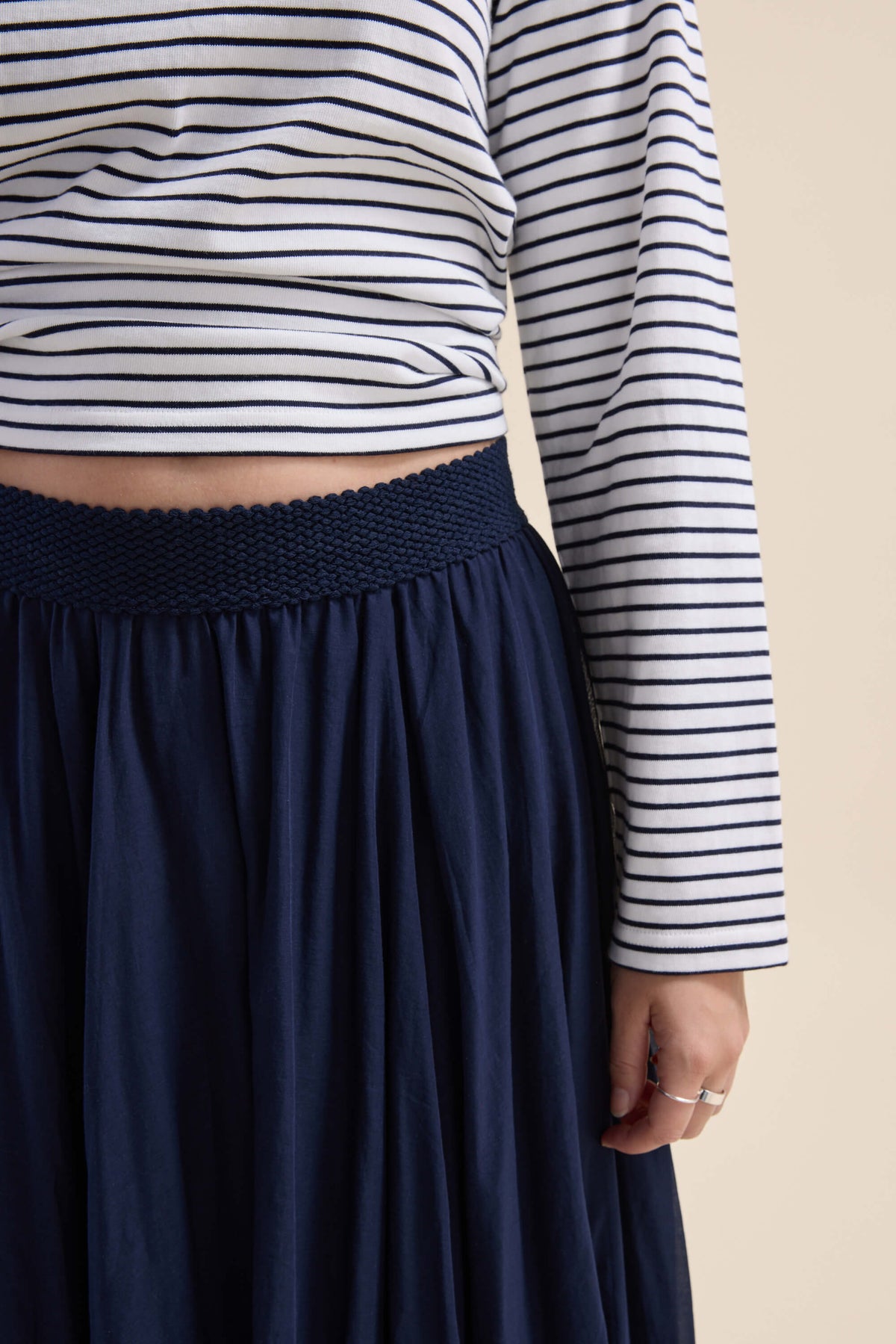 Model in a striped top and the Elementary Gathered Skirt by Elementary, shown waist to mid-thigh.