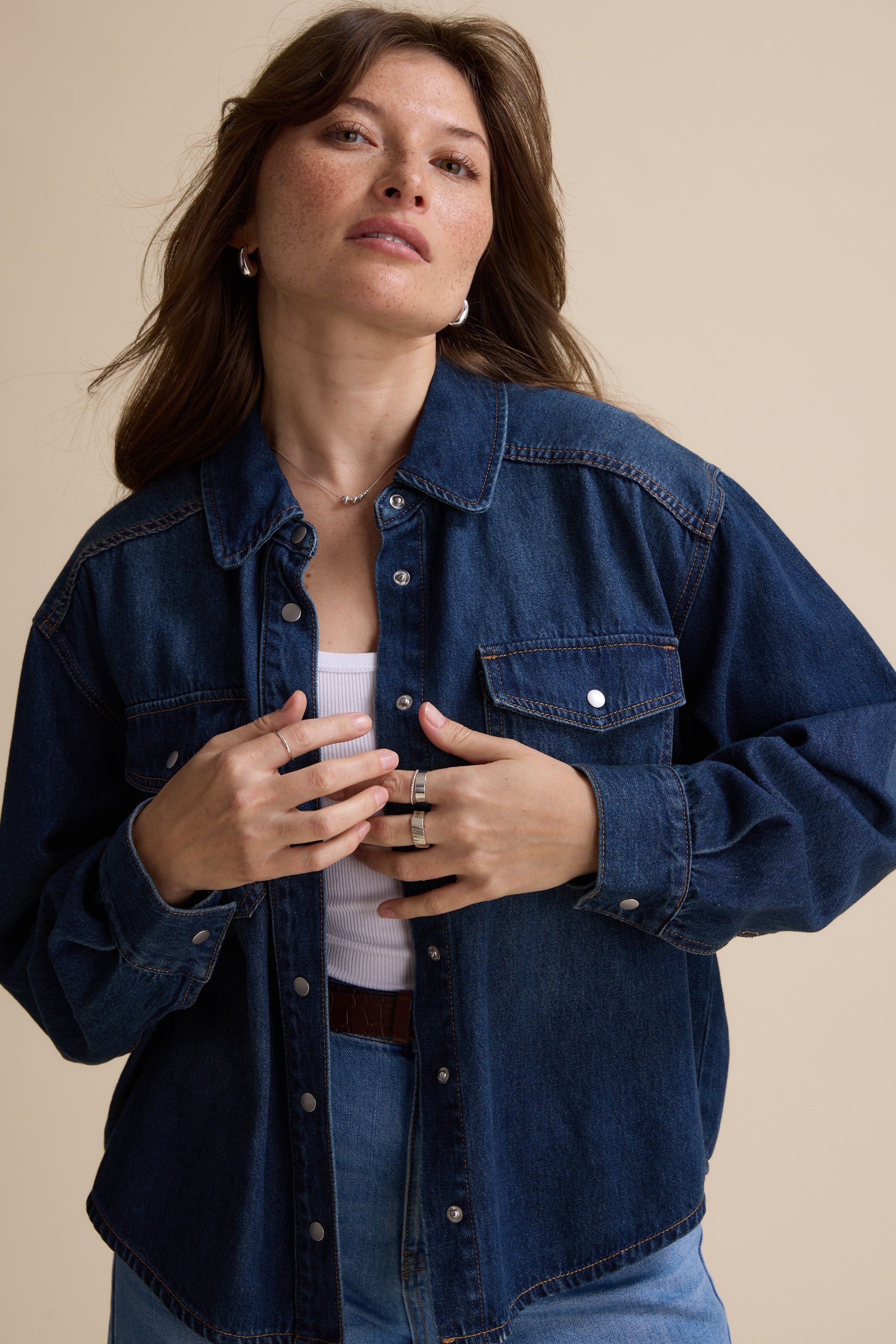 Woman in Max's Sabrina Cropped Denim Jacket, indigo wash, over a white top.