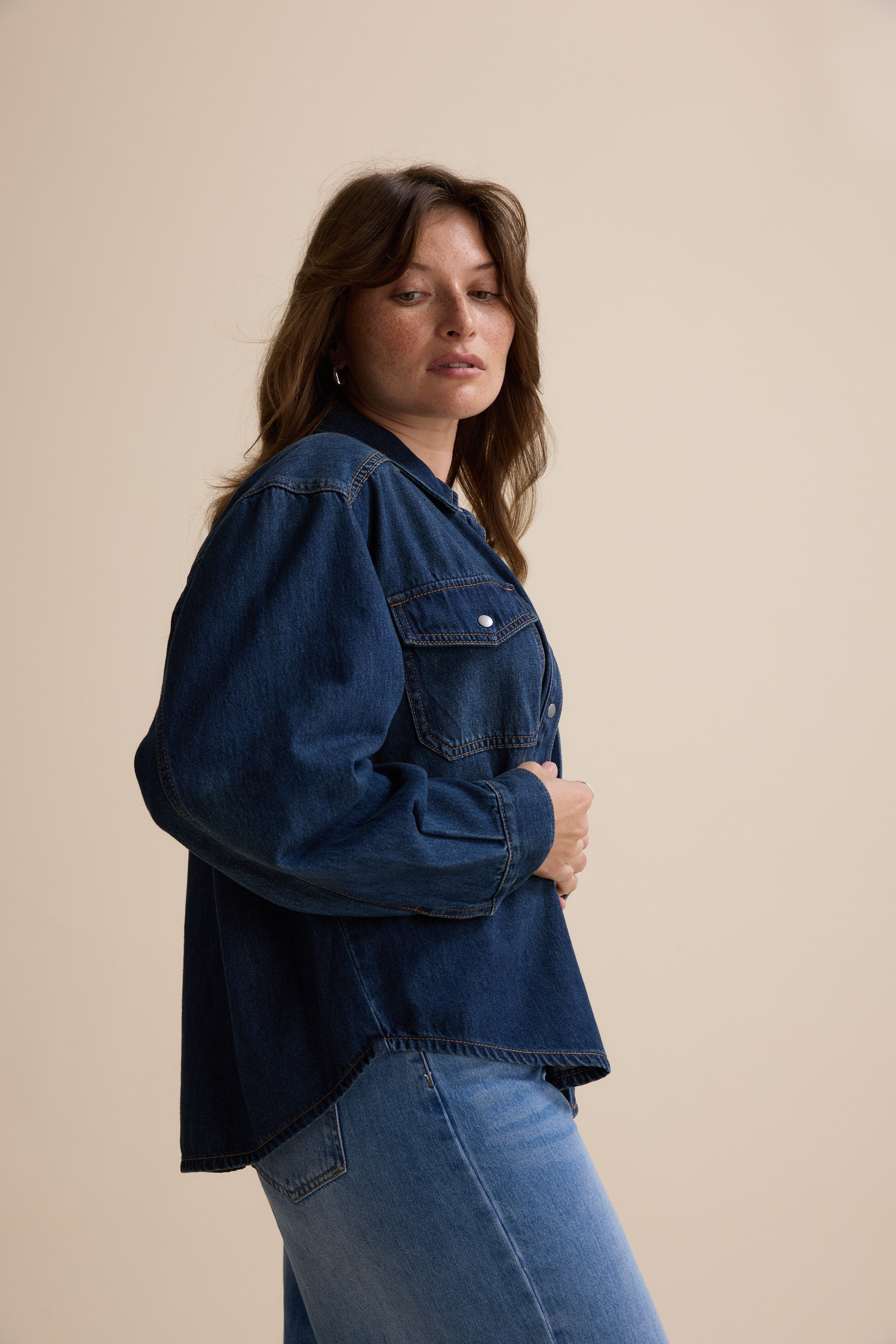 Woman wears the Max Sabrina Cropped Denim Jacket and jeans against a plain beige background.
