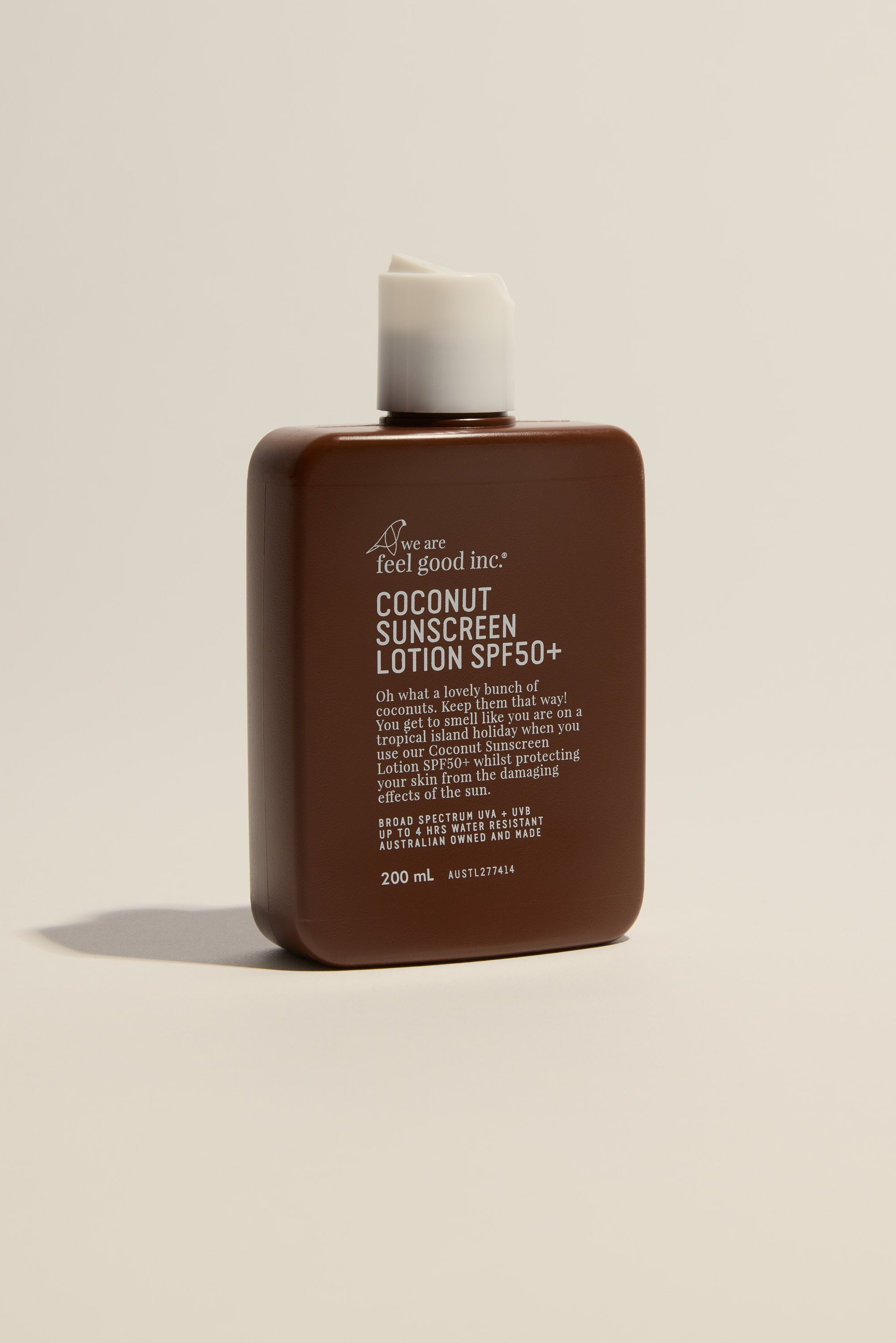 A brown rectangular bottle of We Are Feel Good Signature Sunscreen SPF50+ 200ml, with broad spectrum protection and a white flip-top cap, stands against a plain light background. White text is visible on the front.