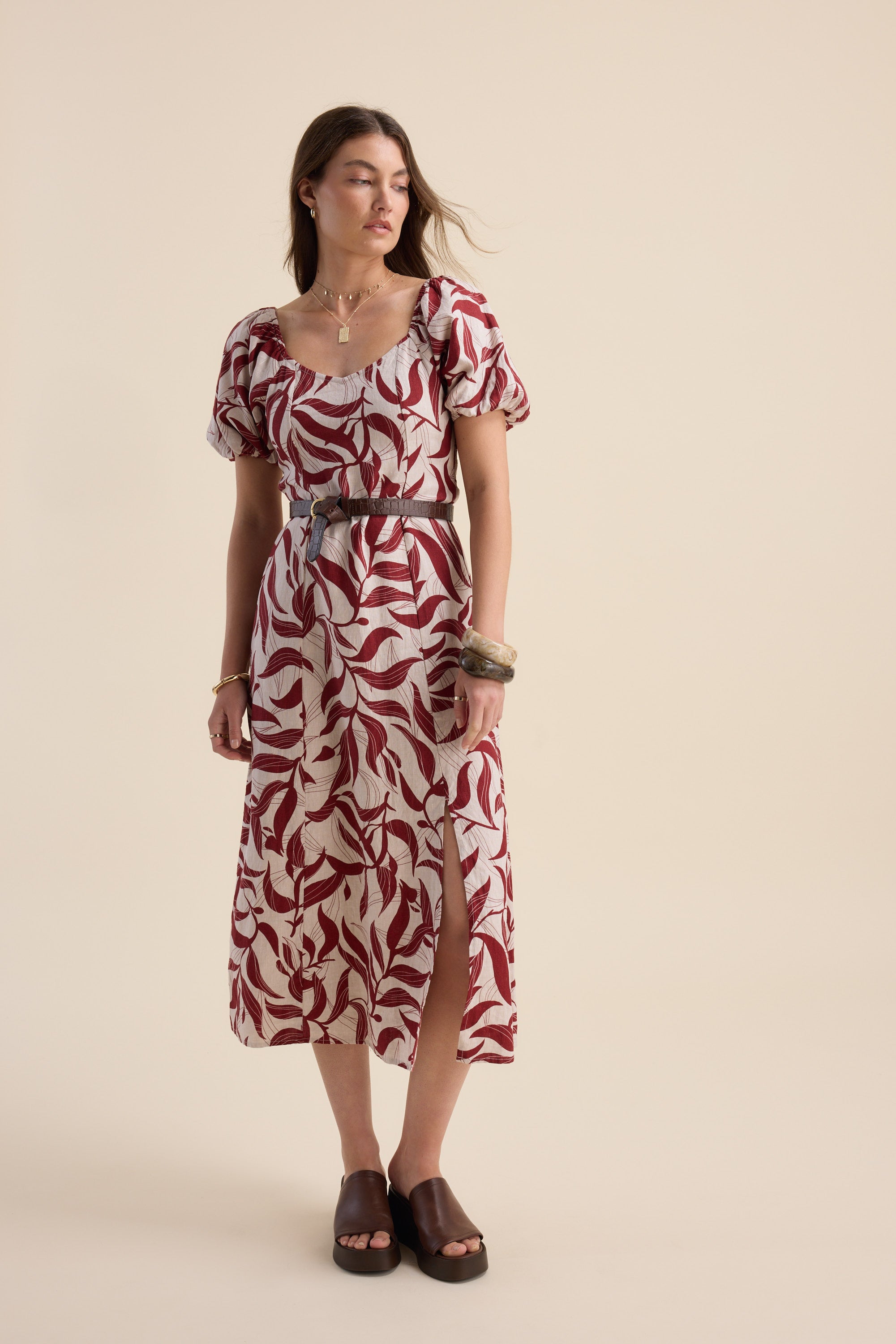Woman in Max Camille Puff Sleeve Dress with black belt and brown sandals.