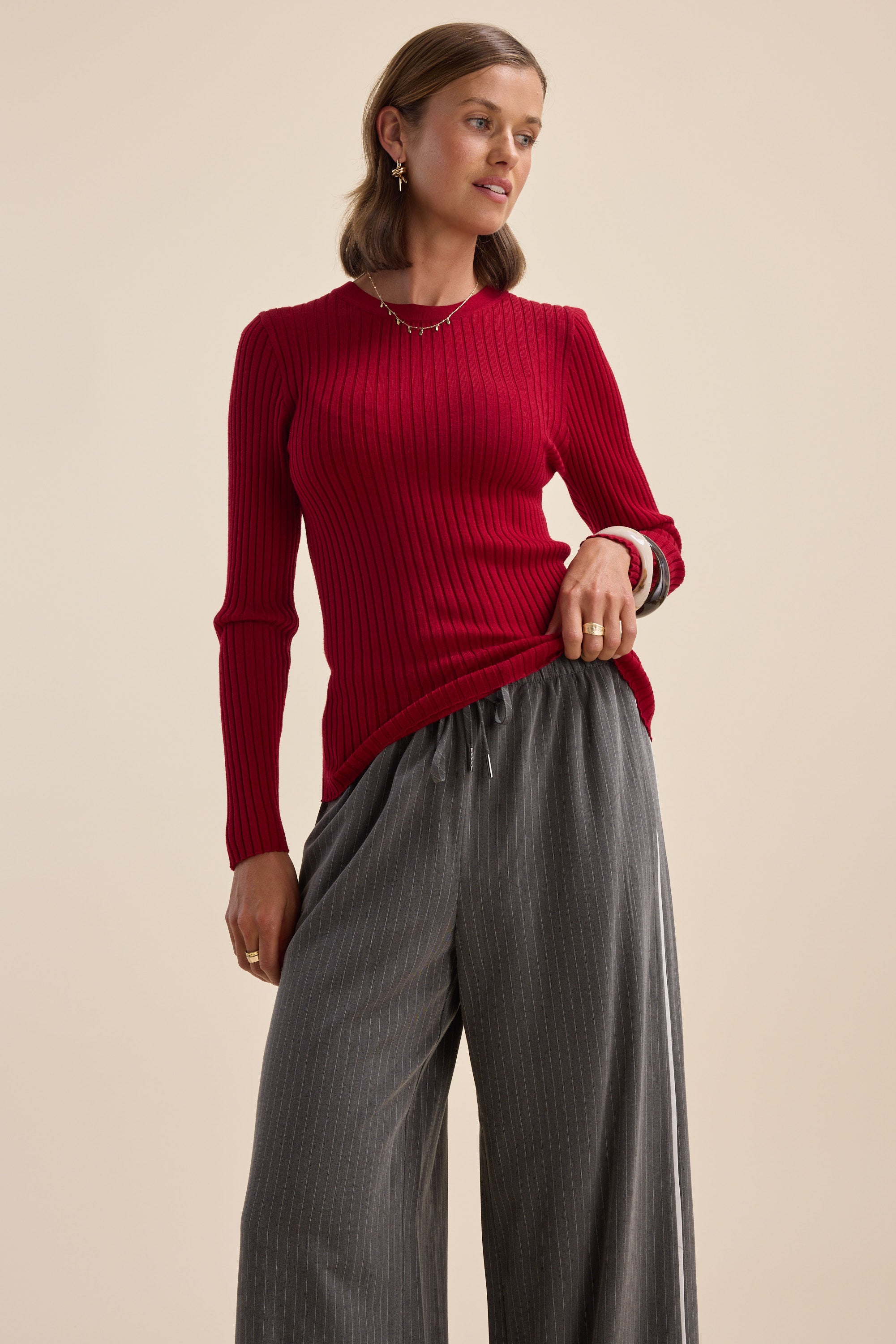 Woman wearing the Elementary ZQ Merino Crew Neck Top by Elementary, standing against a neutral backdrop.
