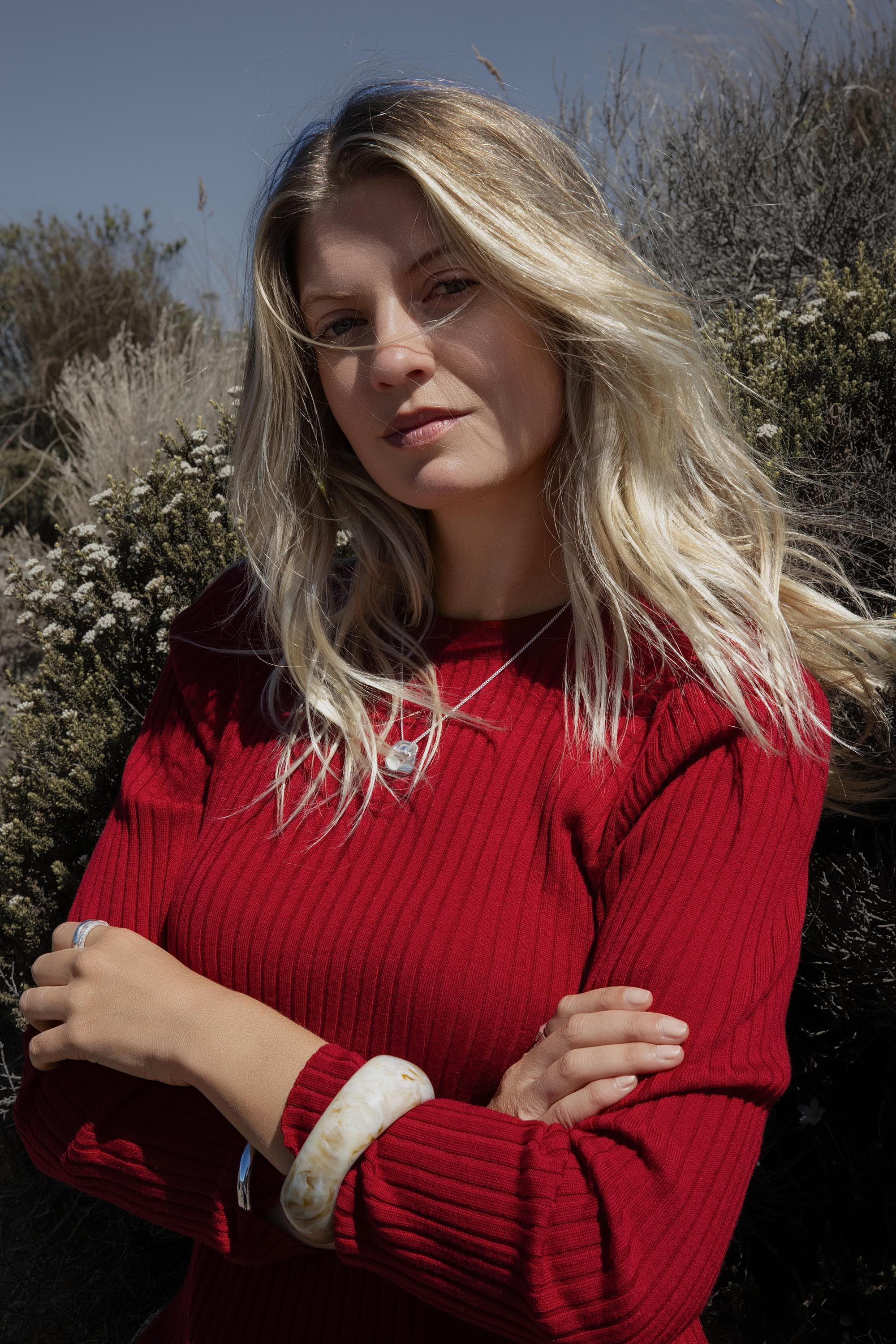 Woman wears Elementary ZQ Merino Crew Neck Top, perfect for winter layering, arms crossed outdoors.