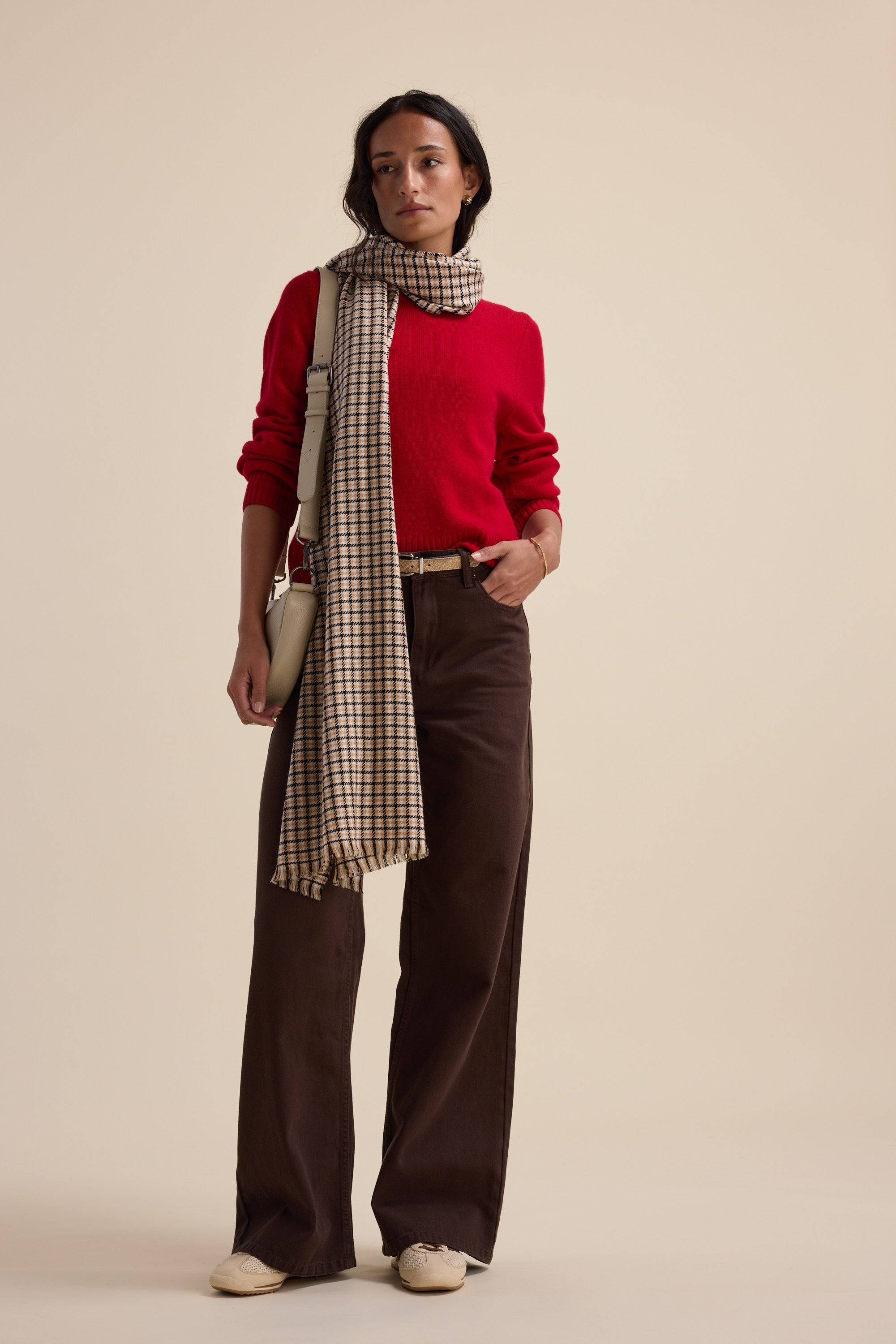 Woman in Elementary Cashmere Blend Crew Neck Sweater, brown pants, and plaid scarf on beige.