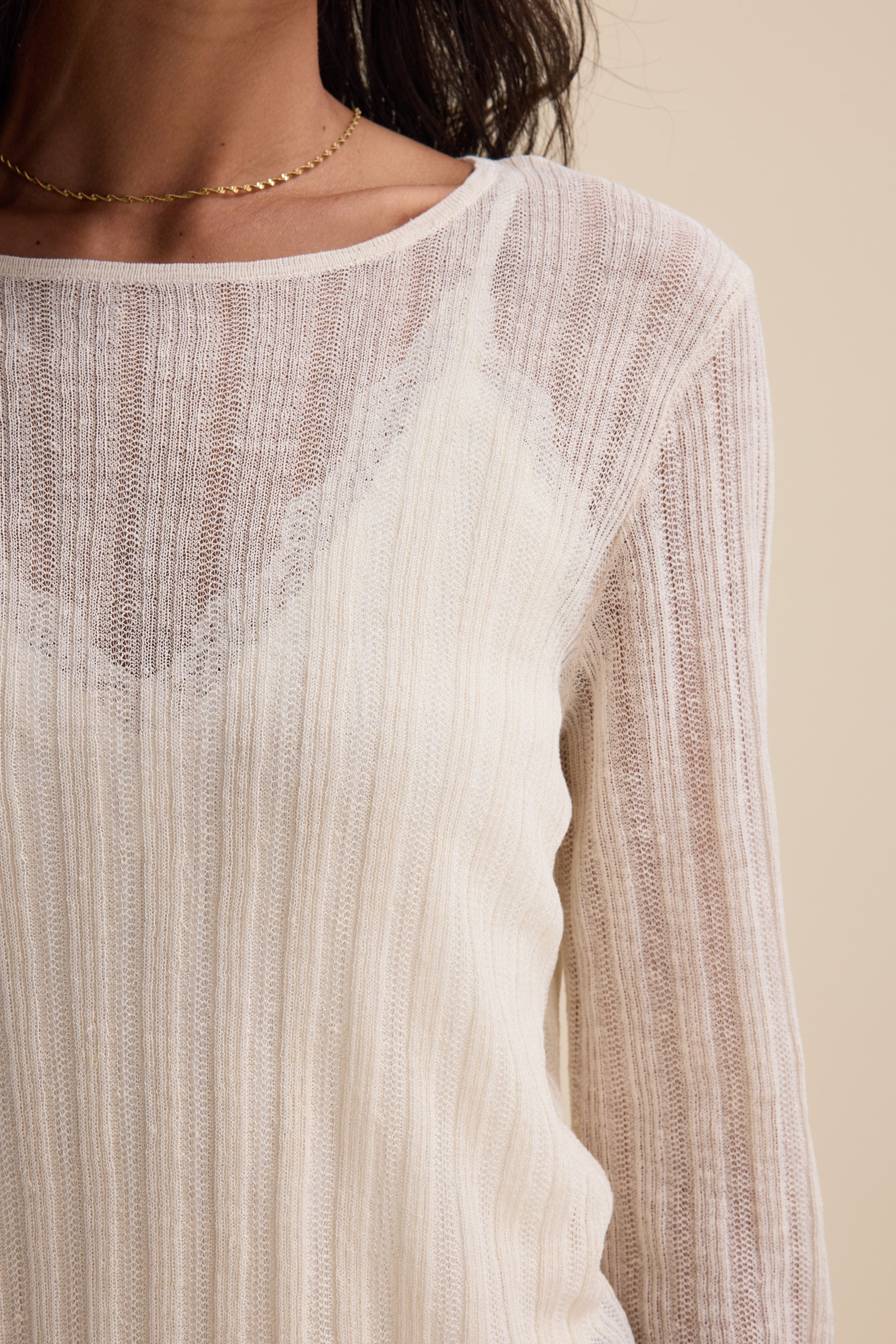 Woman in the Elementary Knitted Layering Top and a delicate gold chain necklace.