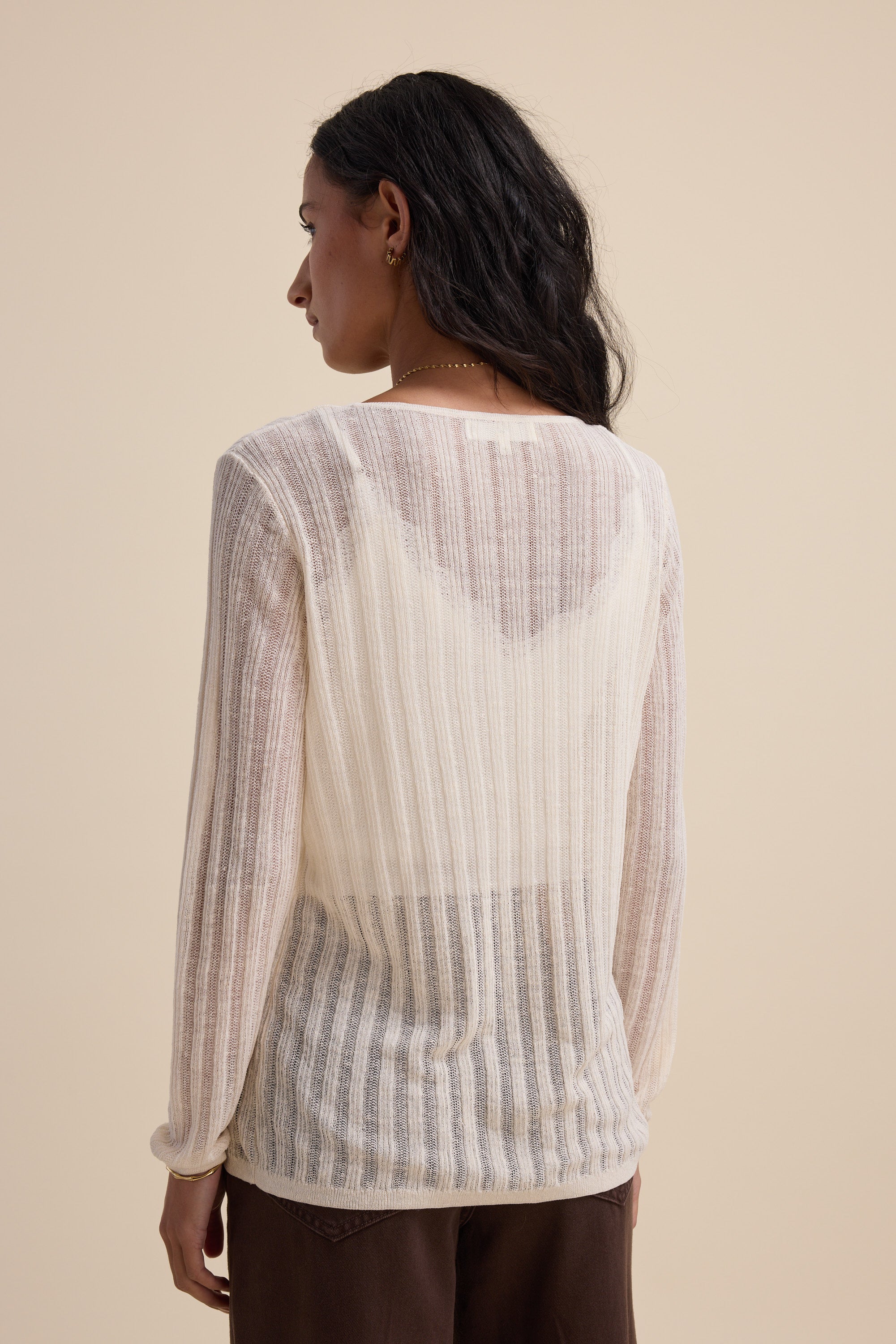 Person wearing the Elementary Knitted Layering Top in ivory, viewed from the back.