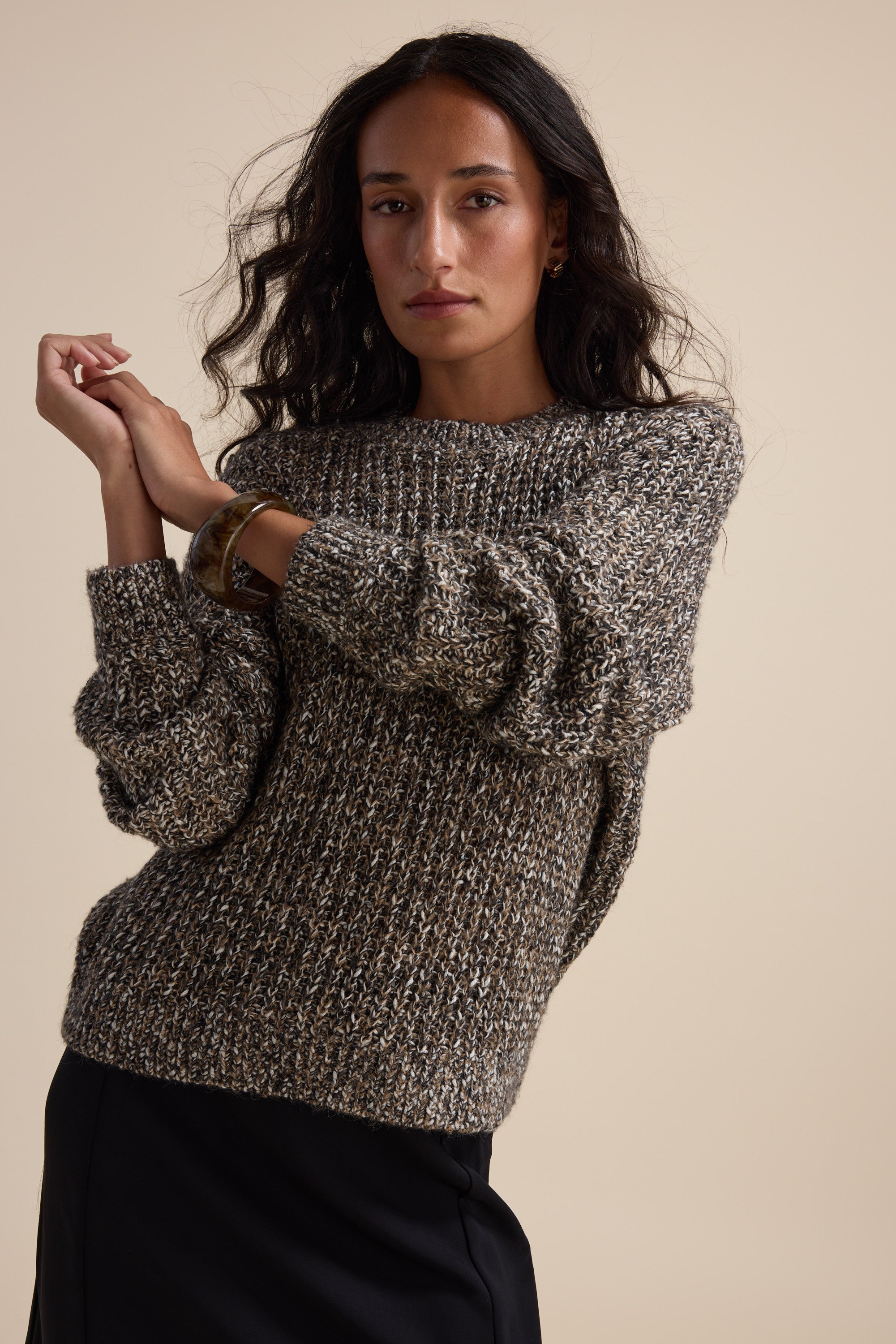Woman in the Elementary Chunky Knit Sweater poses against a plain beige background.