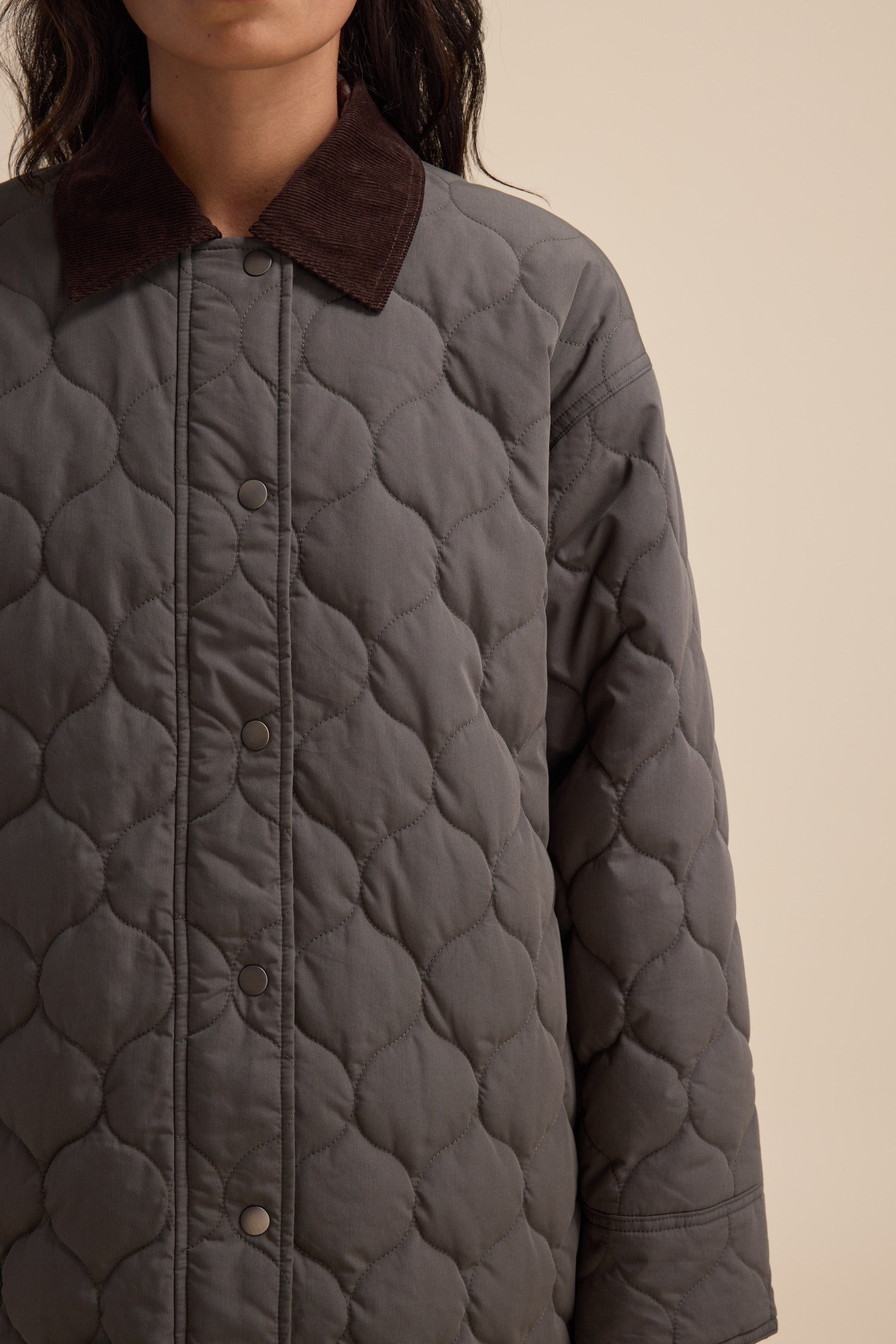A person in the Elementary Longline Puffer by Elementary, shown from the shoulders down.