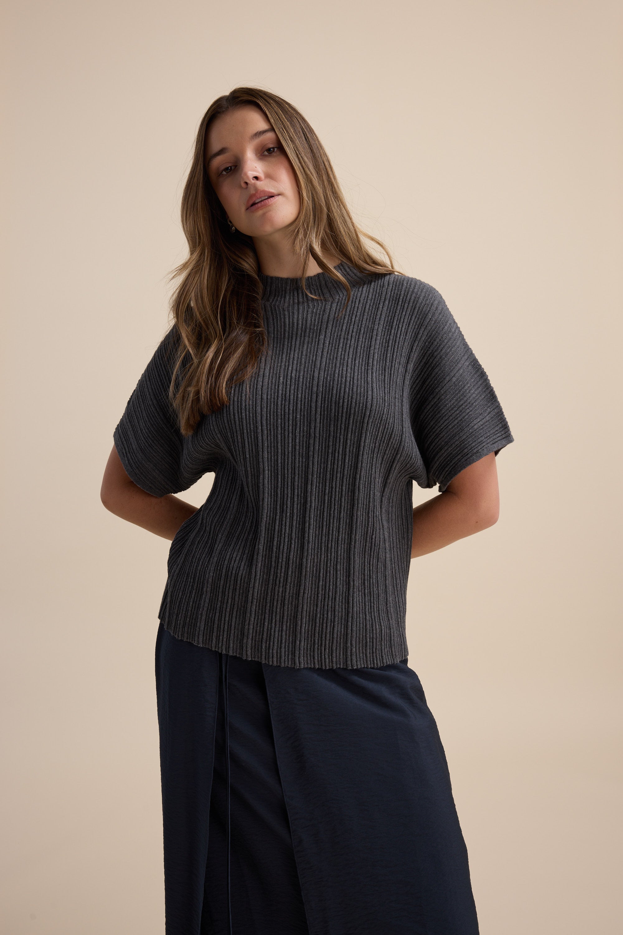 Woman in Max Briana Cotton Cashmere Ribbed Top and navy skirt against a plain beige background.