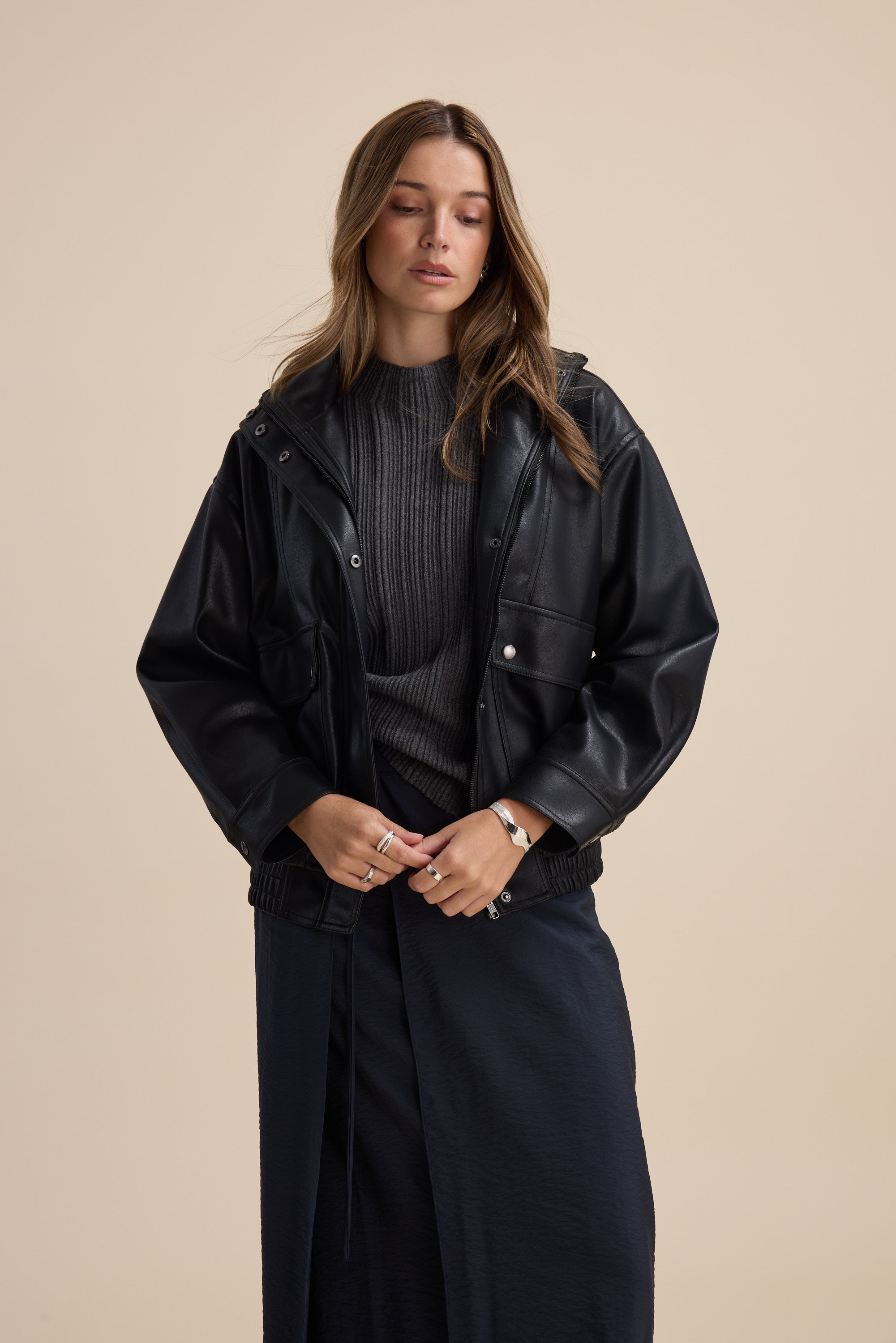 Woman in Briana Cotton Cashmere Ribbed Top by Max, black jacket, dark skirt, beige background.