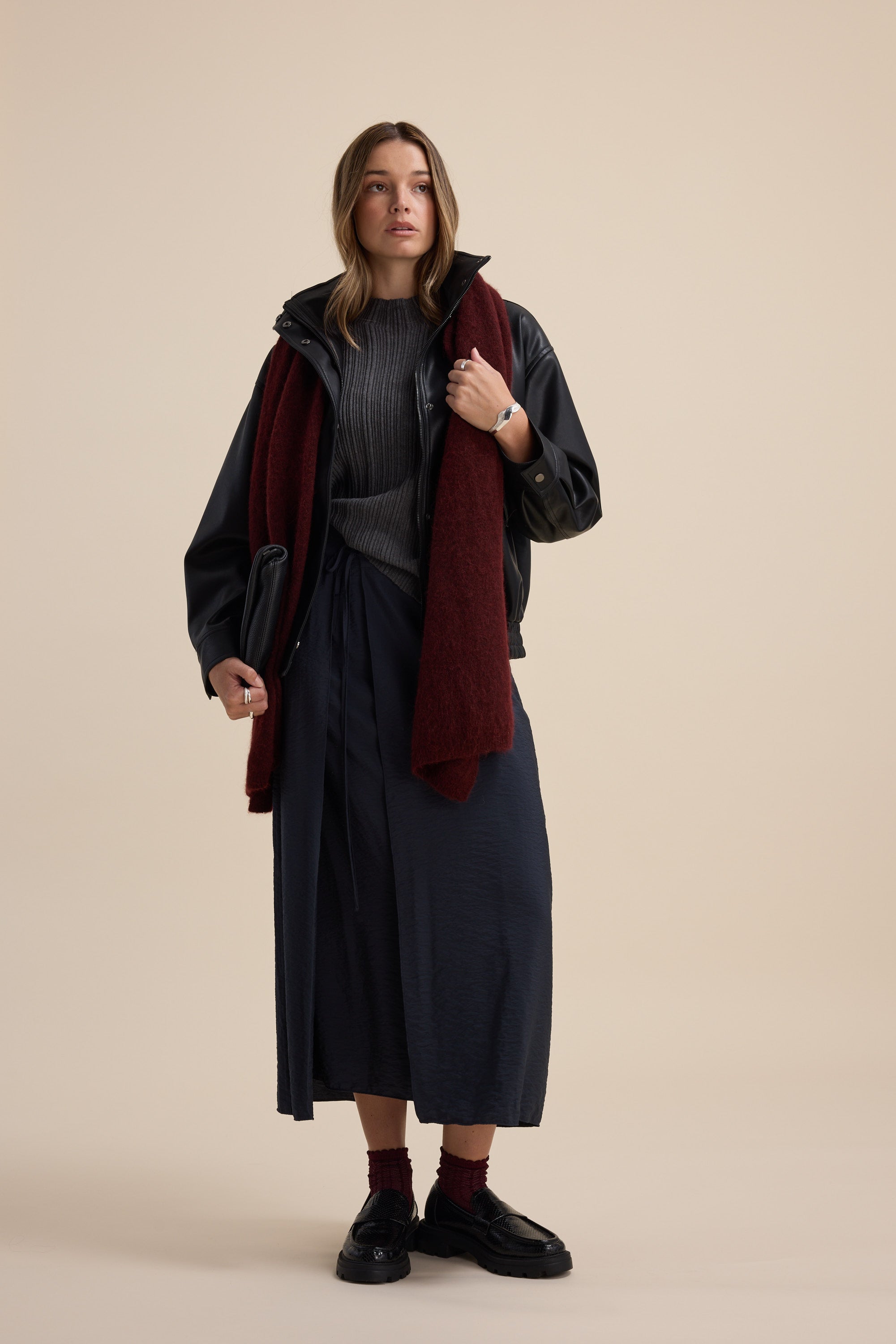 Woman in Briana Cotton Cashmere Ribbed Top by Max, styled in layers against a beige background.