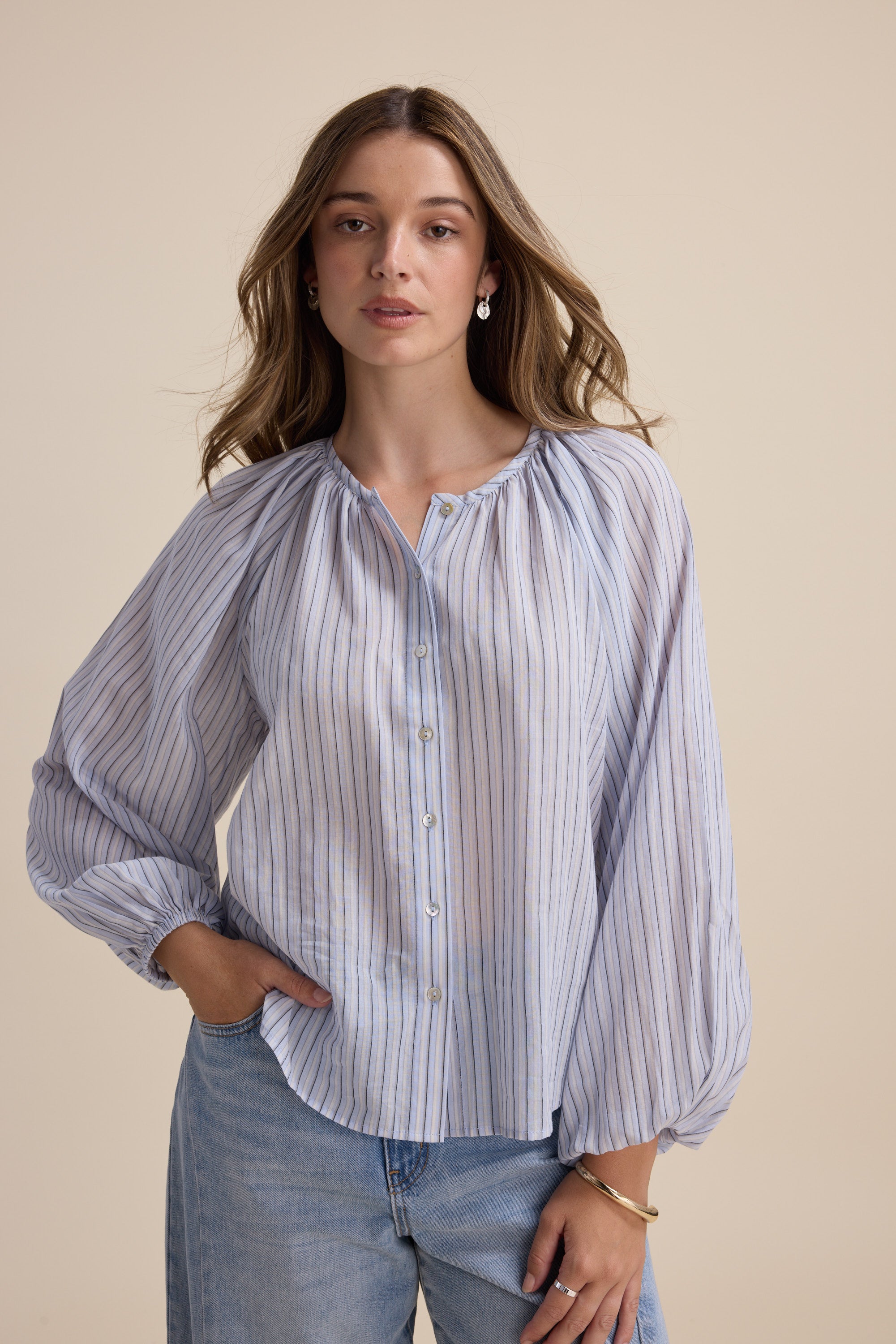 Woman in the Max Vivian Button Front Blouse, organic cotton with blouson sleeves and jeans.