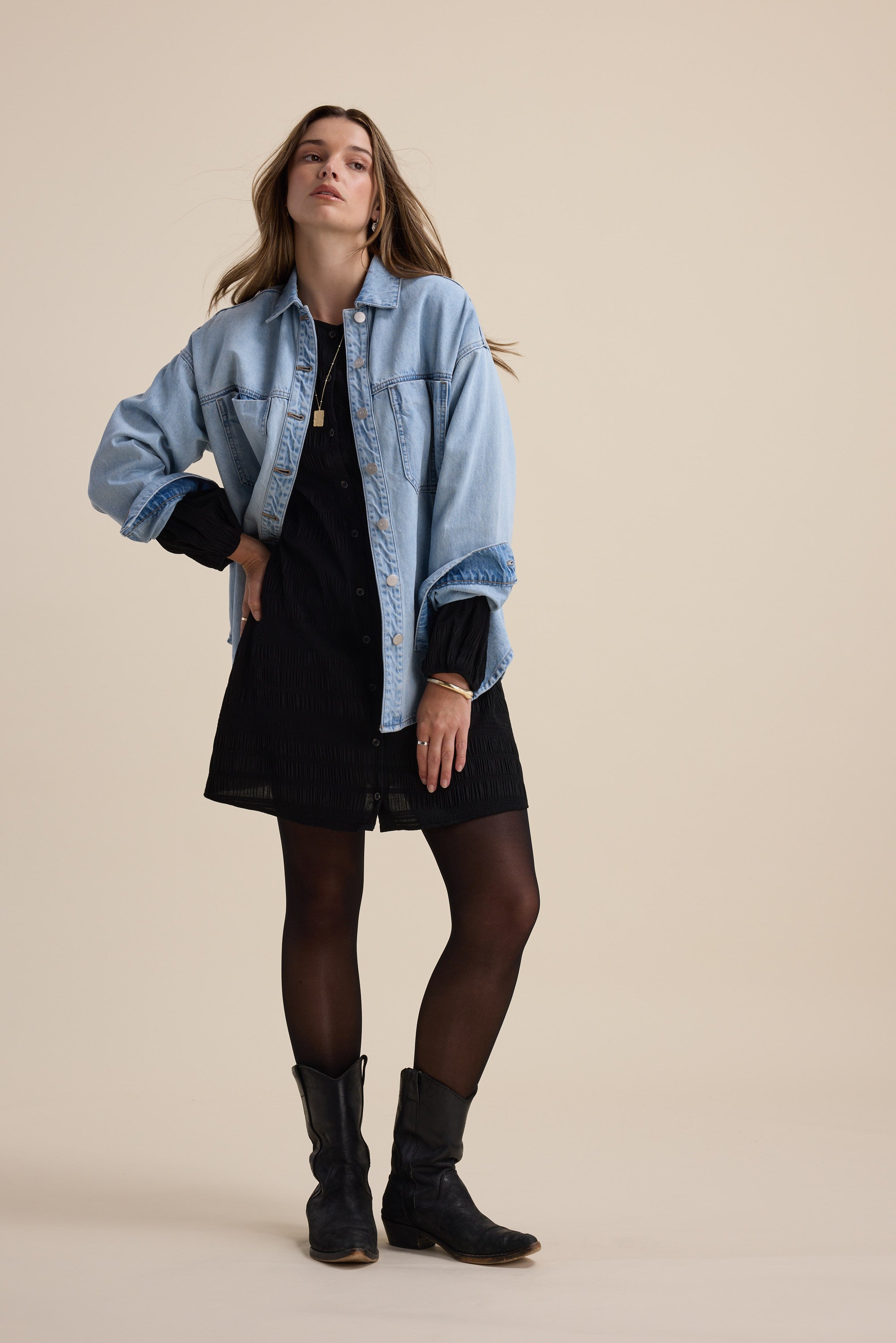 Woman in the Tessa Textured Button Front Dress by Max, styled with a denim jacket and boots.