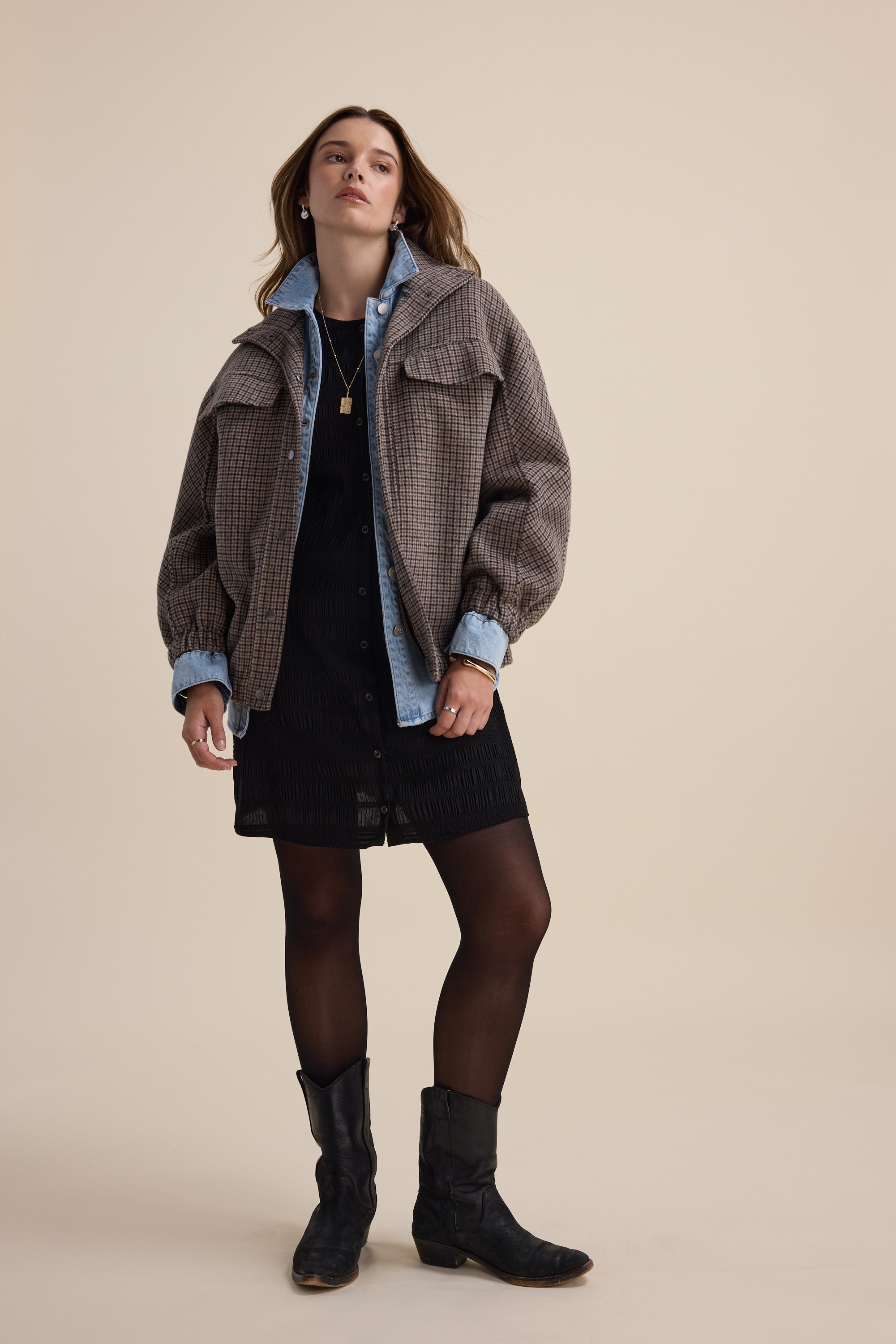Woman in Max's Tessa Textured Button Front Dress and boots stands against a beige background.
