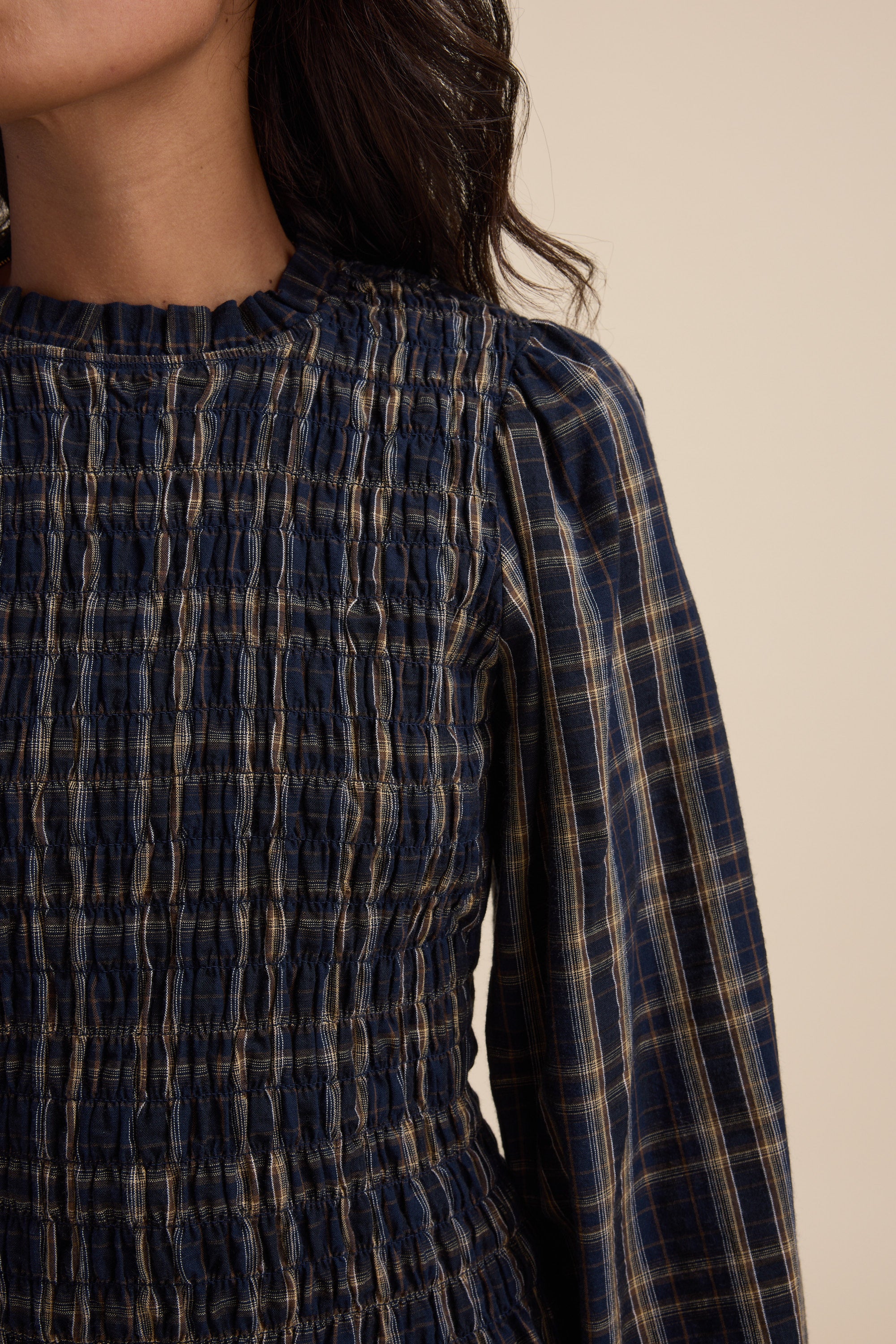 Woman in navy check Elementary Shirred Long Sleeve Top, shown shoulders to waist.