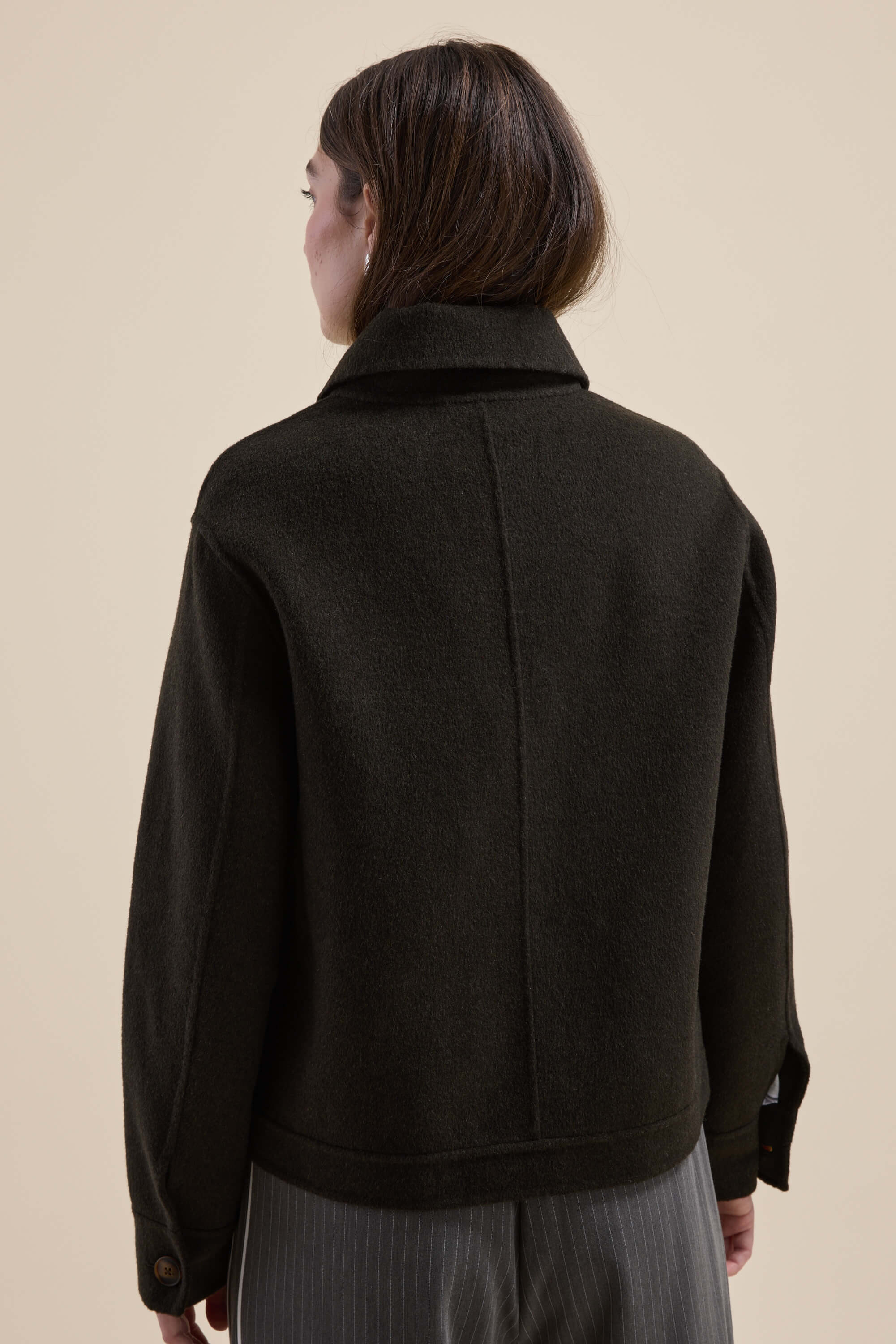 Woman in the Kaia Wool Blend Cropped Coat by Max, seen from behind against a beige background.