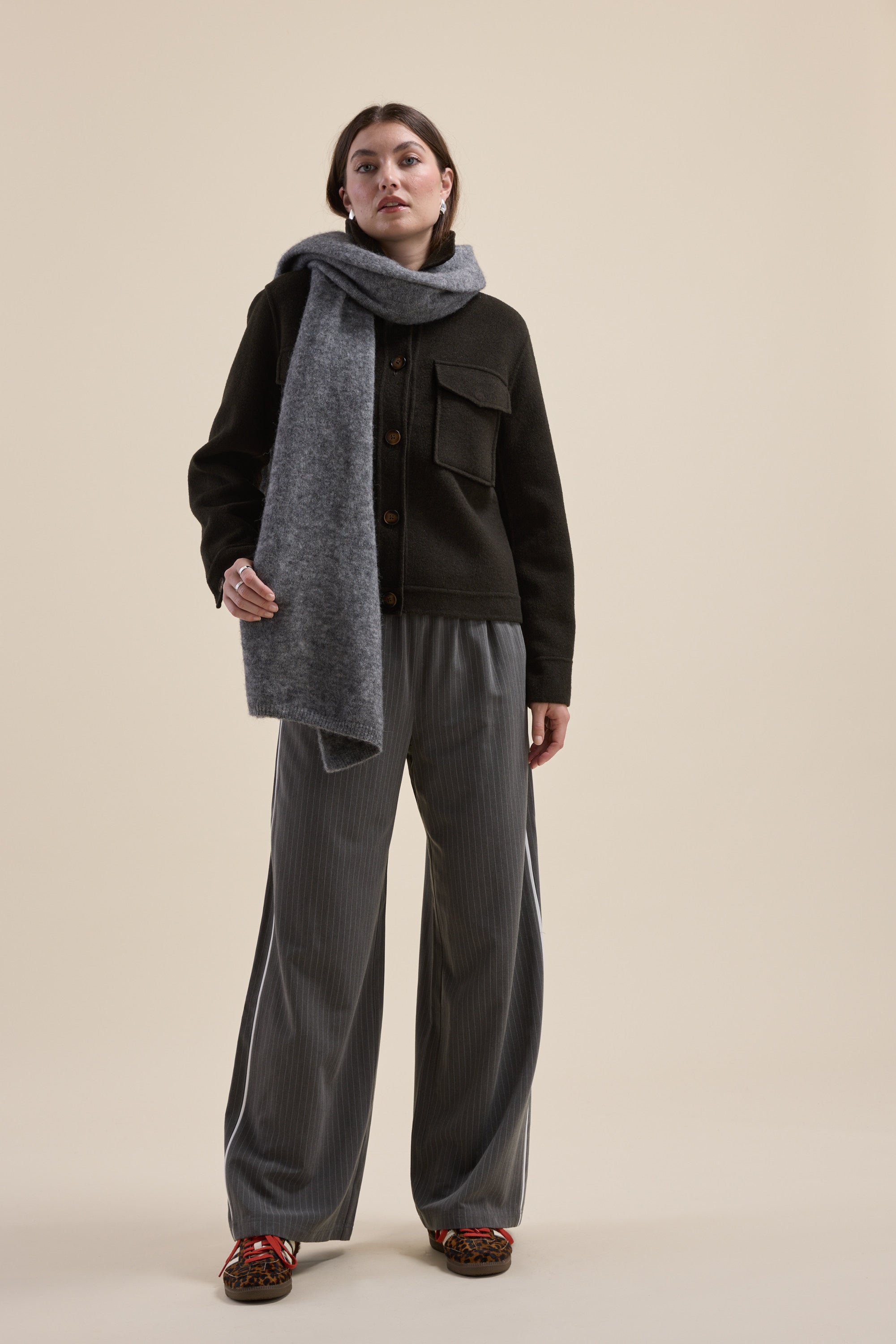 Woman in loose gray pants, recycled wool scarf, and Max Kaia Wool Blend Cropped Coat stands.