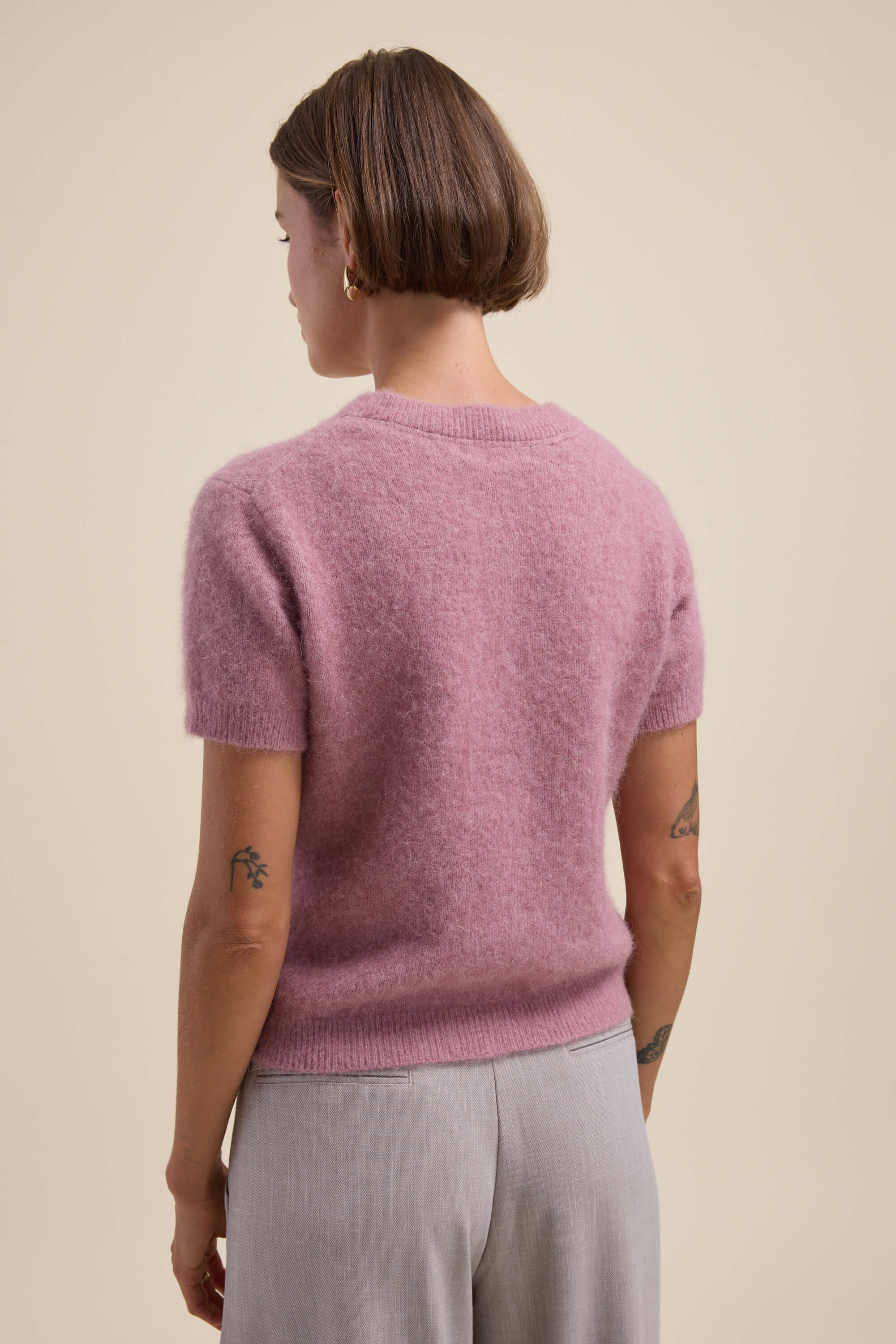 Person with short brown hair wears Max Adelaide Luxe Whisper Cardigan and light pants, facing away.