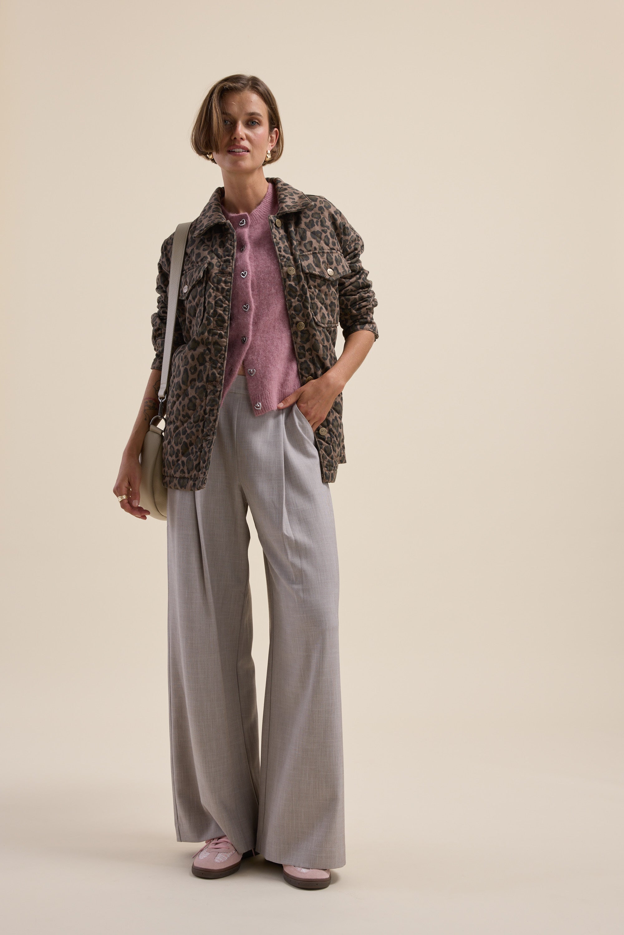 Woman in an Adelaide Luxe Whisper Cardigan by Max, wide gray pants, and pink shoes posing.