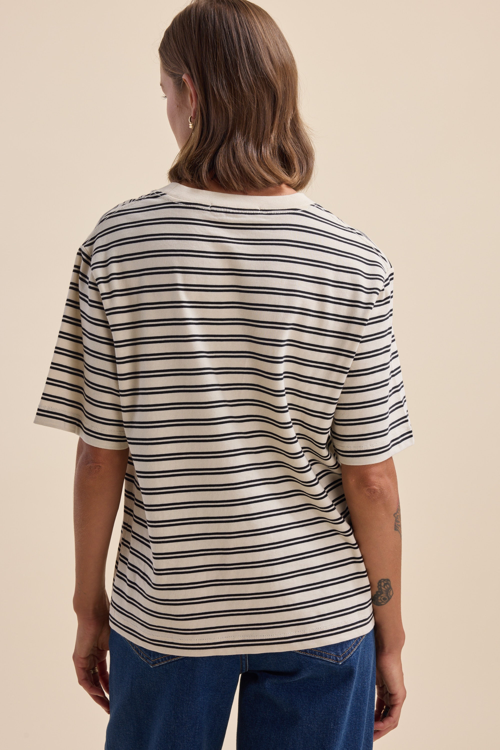 Person wearing Max Charmaine Organic/Pima Cotton Tee in black and white stripes, back view.