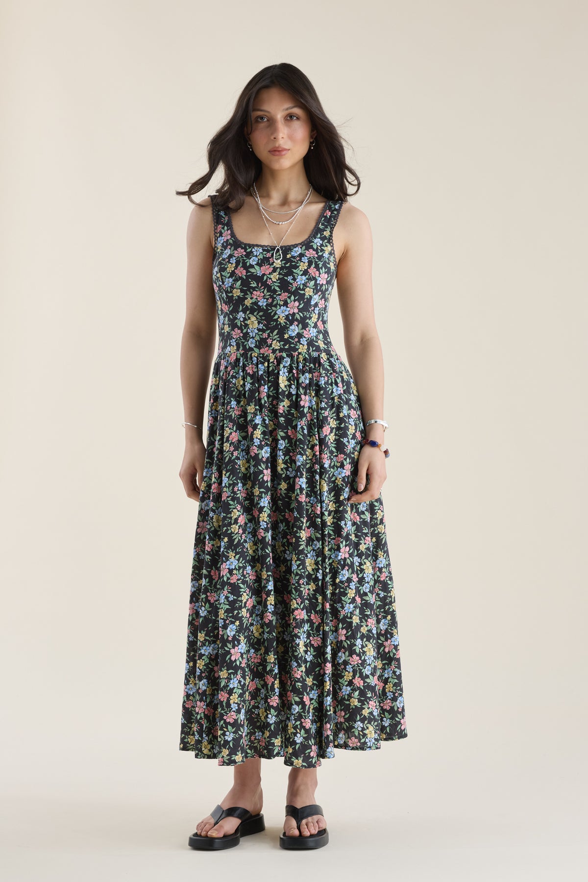 Woman wears Max Aria Gathered Waist Midi Dress, sandals; stands facing forward, plain backdrop.