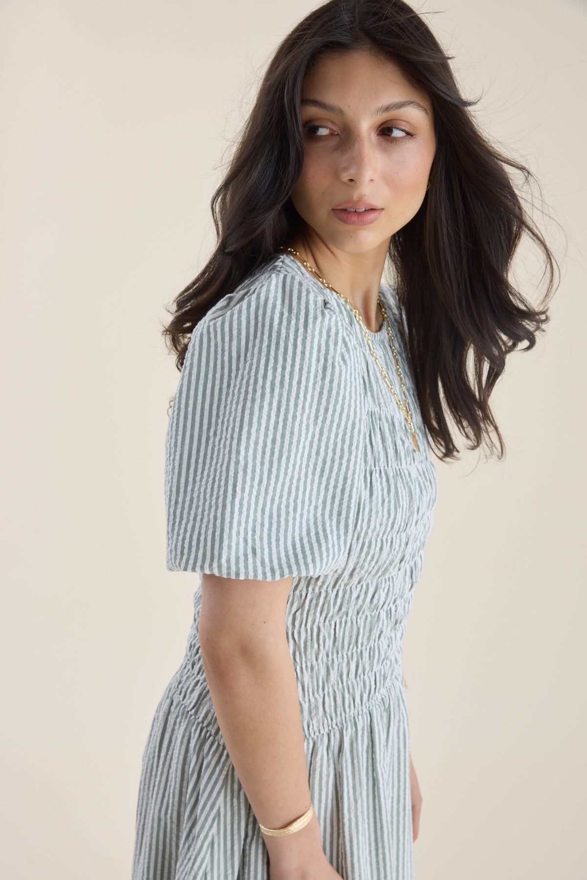Woman in Max’s Talia Shirred Detail Midi Dress looks over her shoulder, serene and chic.