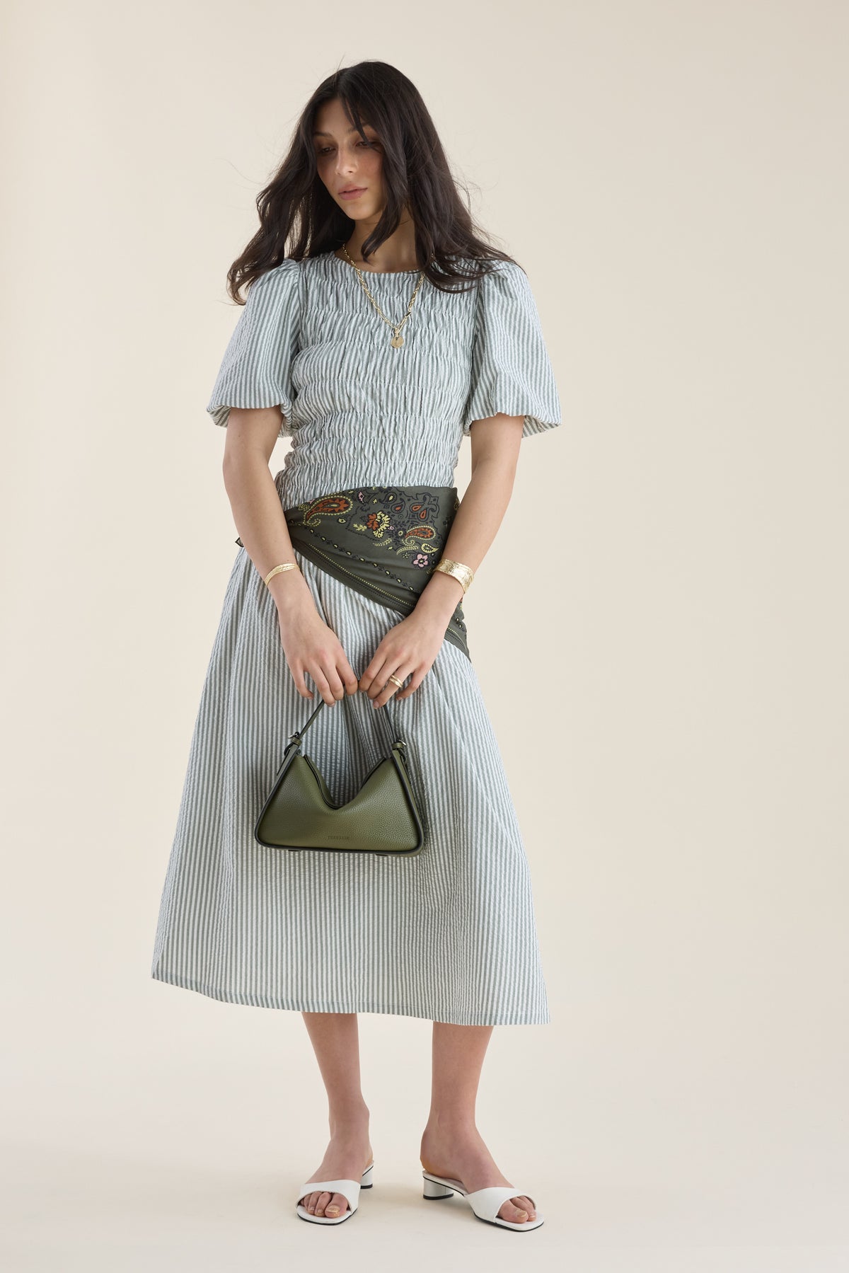 Woman in Max Talia Shirred Detail Midi Dress with puff sleeves, green handbag, neutral background.