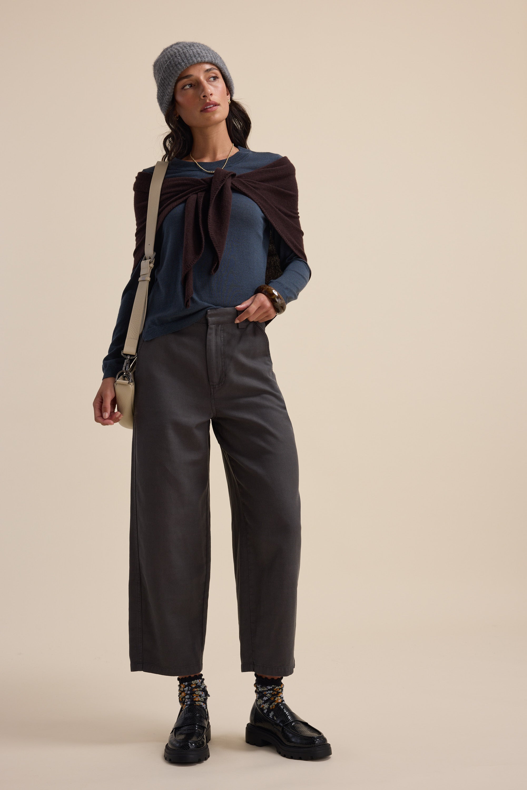 Woman in The Merino Silk Layering Top by Max, wide-leg pants, gray beanie, black shoes.