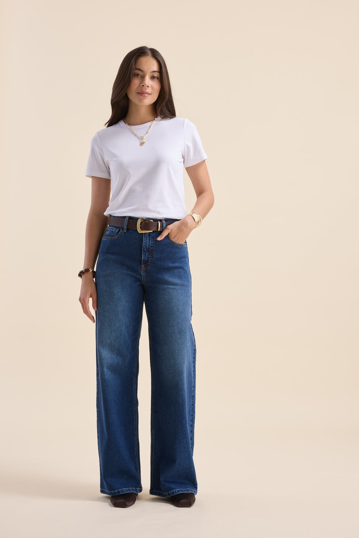 Woman in white tee and Max Nevada Wide jeans stands against beige background.