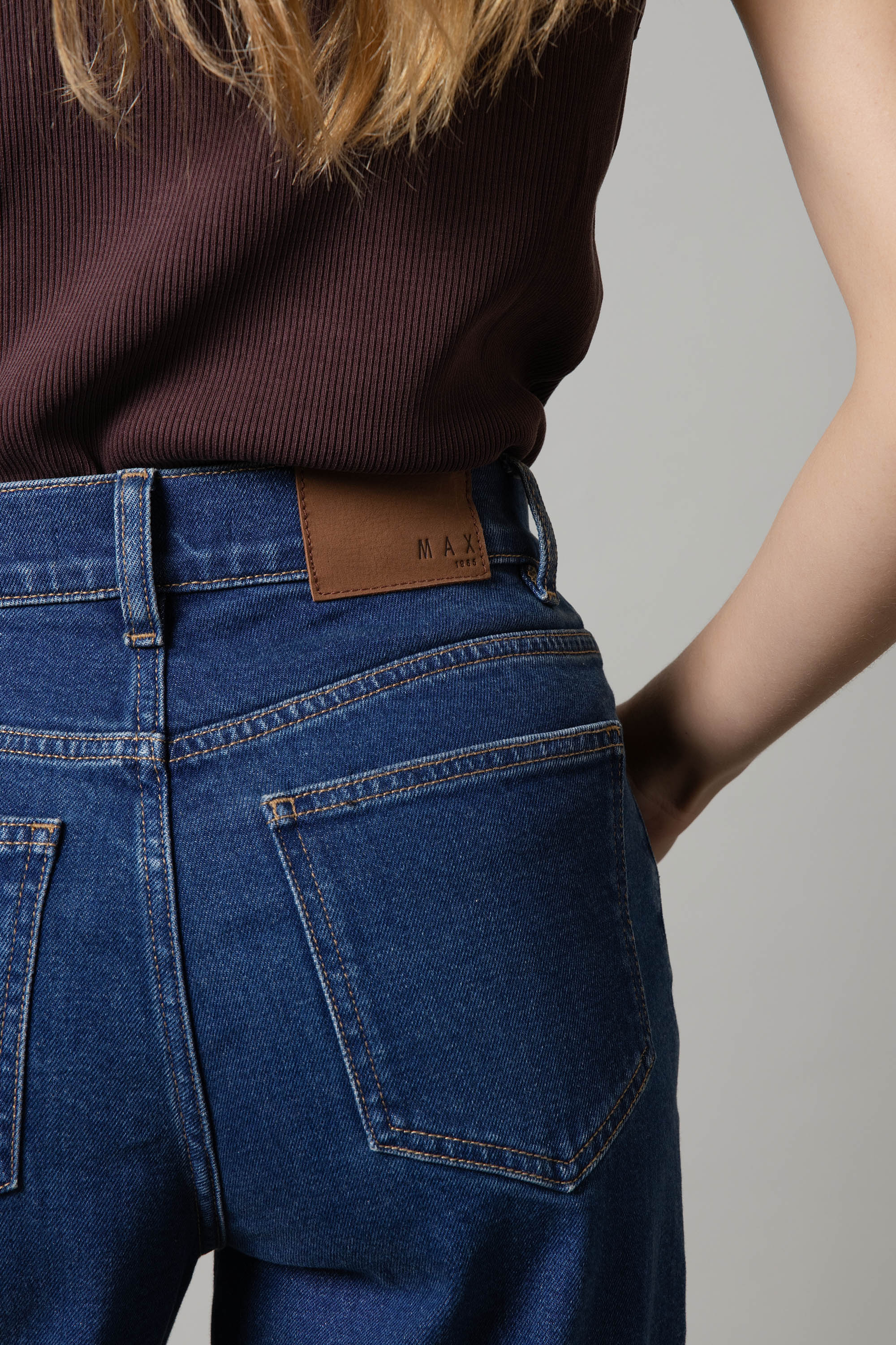 Person in a brown top wears Max Nevada Wide Jeans, shown from the back with hand on hip.