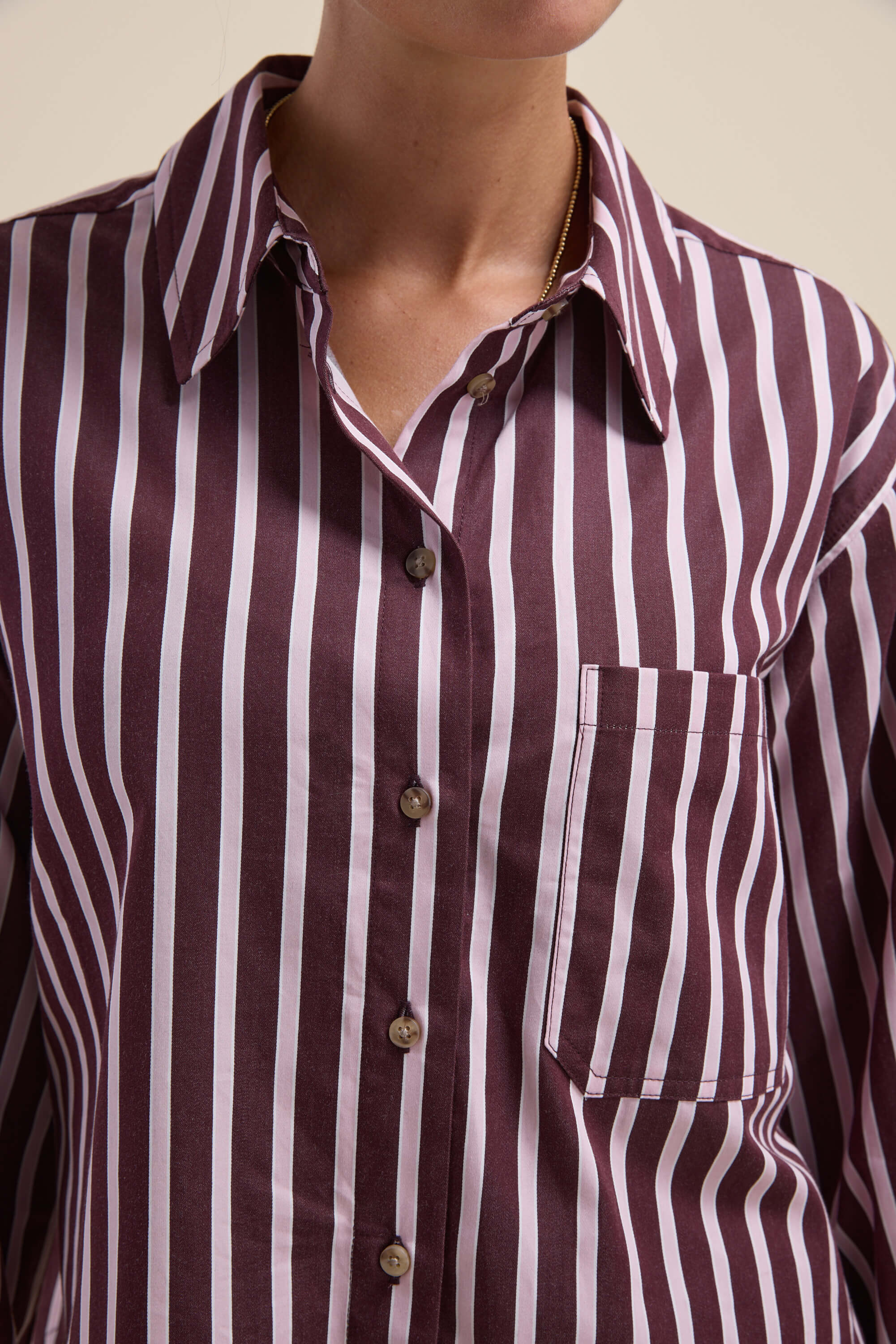 A woman wears the Max Leah Stripe Detail Shirt, a maroon and white cropped collared top.