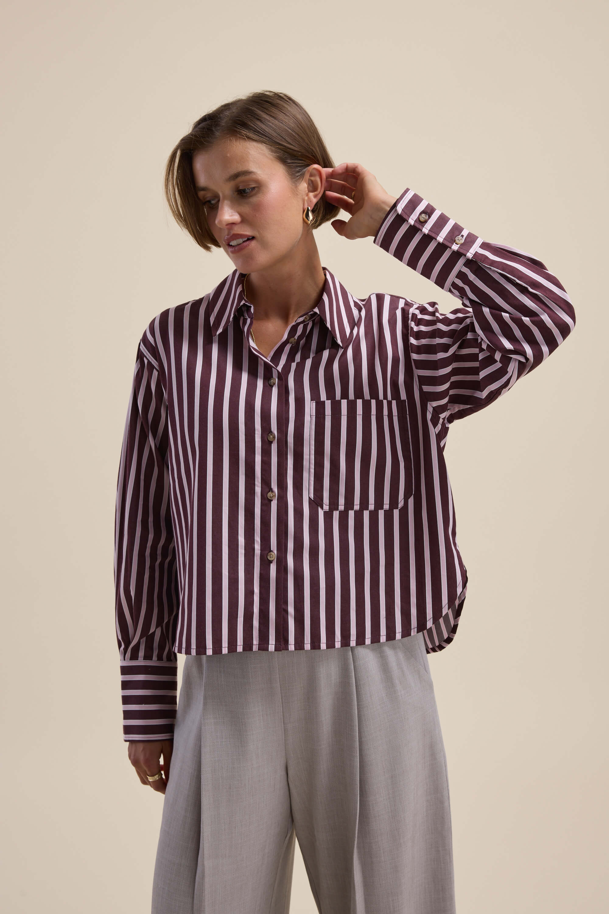 Woman in a Leah Stripe Detail Shirt by Max and light gray pants.