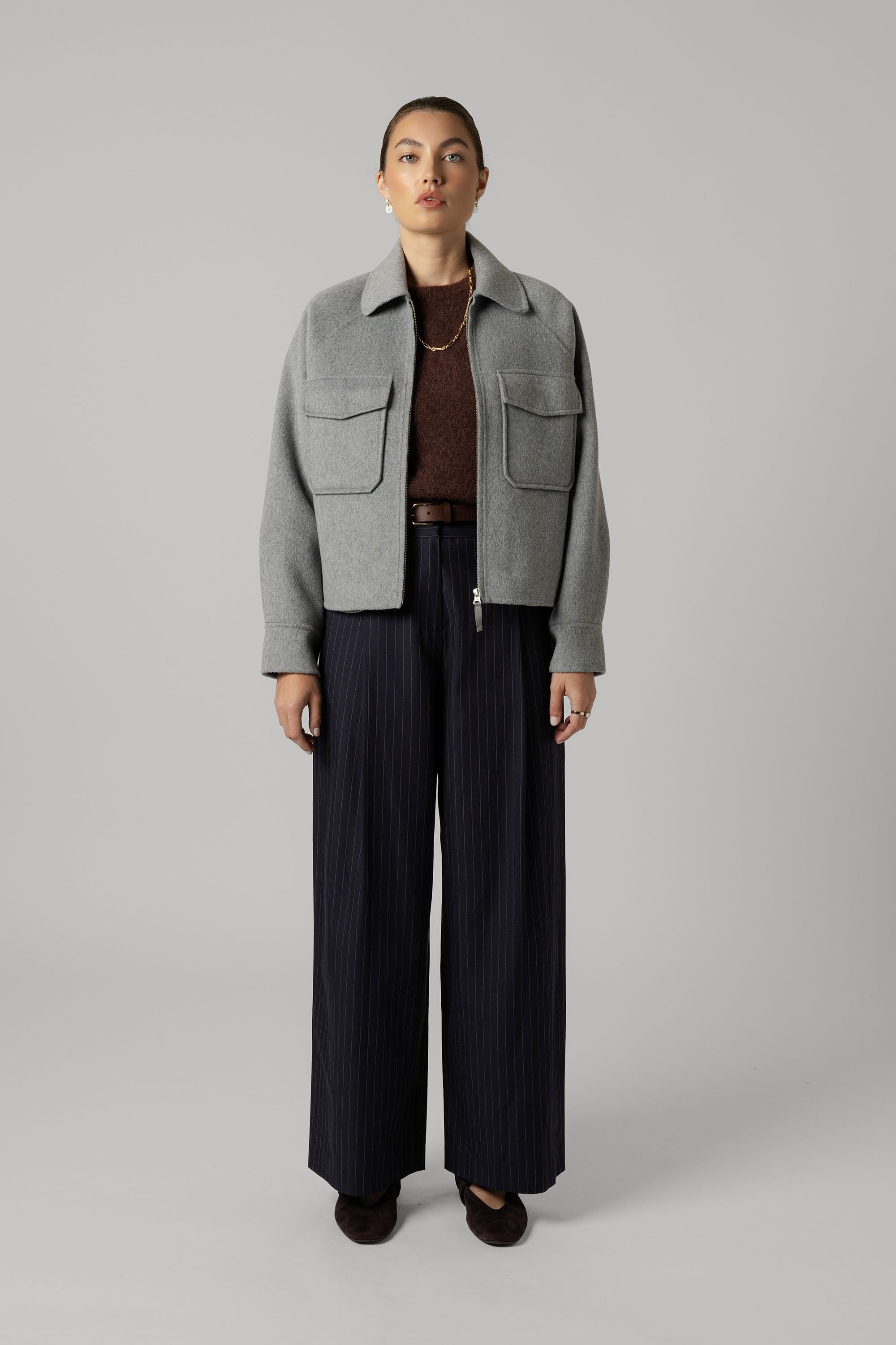 Woman in The Zip Front Wool Blend Cropped Coat by Max, brown top, wide-leg pants, gold necklace.