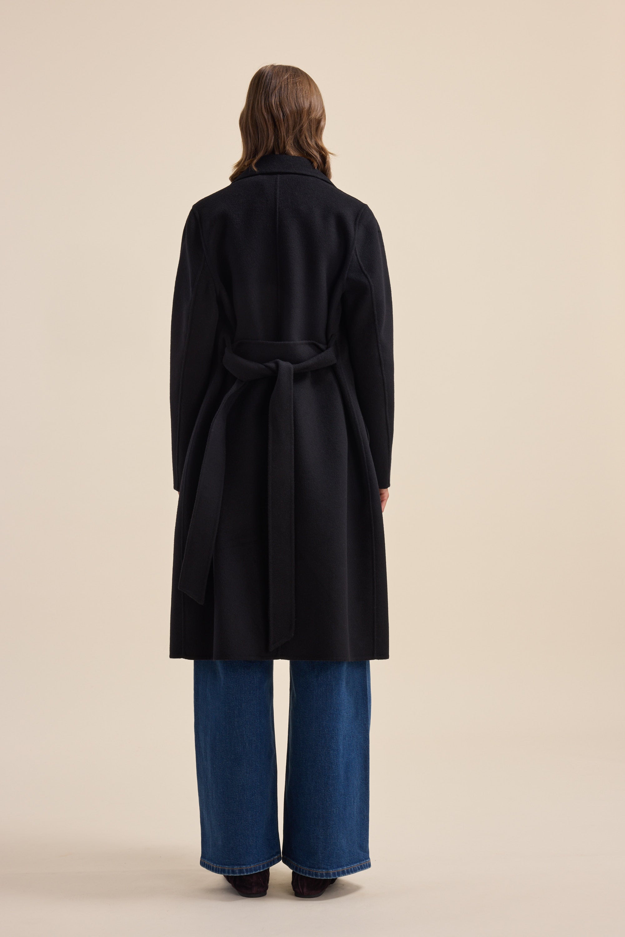 Person in The Belted Wool Coat by Max and wide-leg jeans, back turned to the camera.
