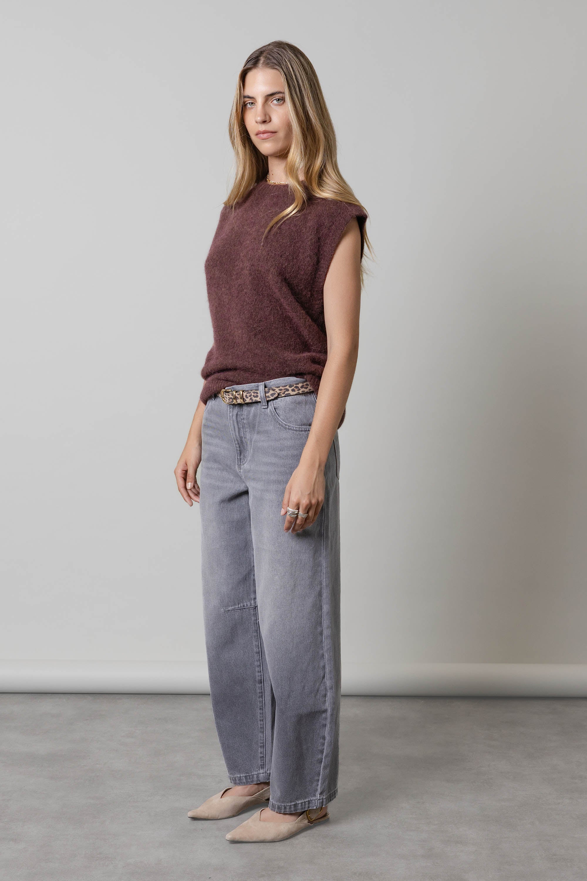 Woman in The Barrel Leg Jeans by Max, maroon top, and beige heels standing indoors.
