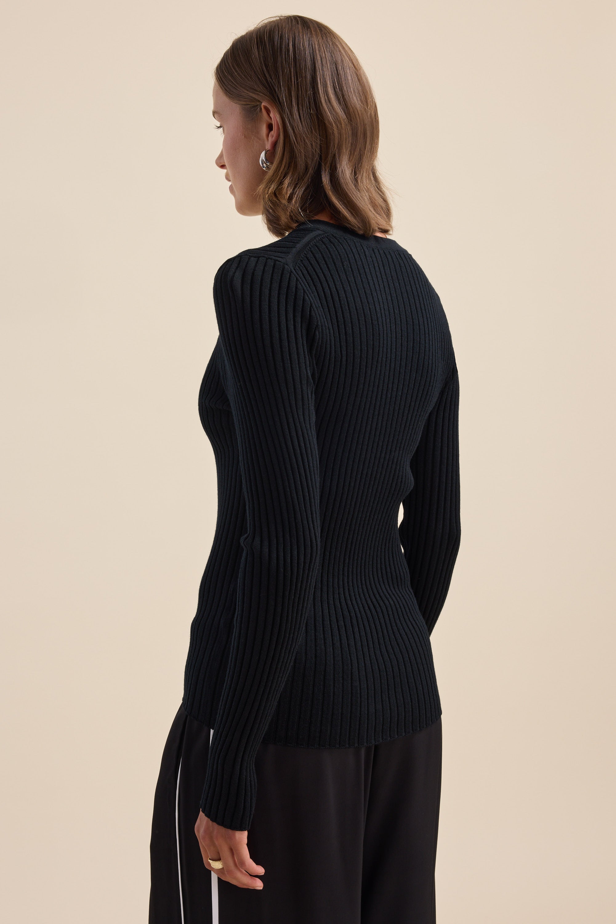 Woman in an Elementary ZQ Merino V Neck Top, seen from behind.